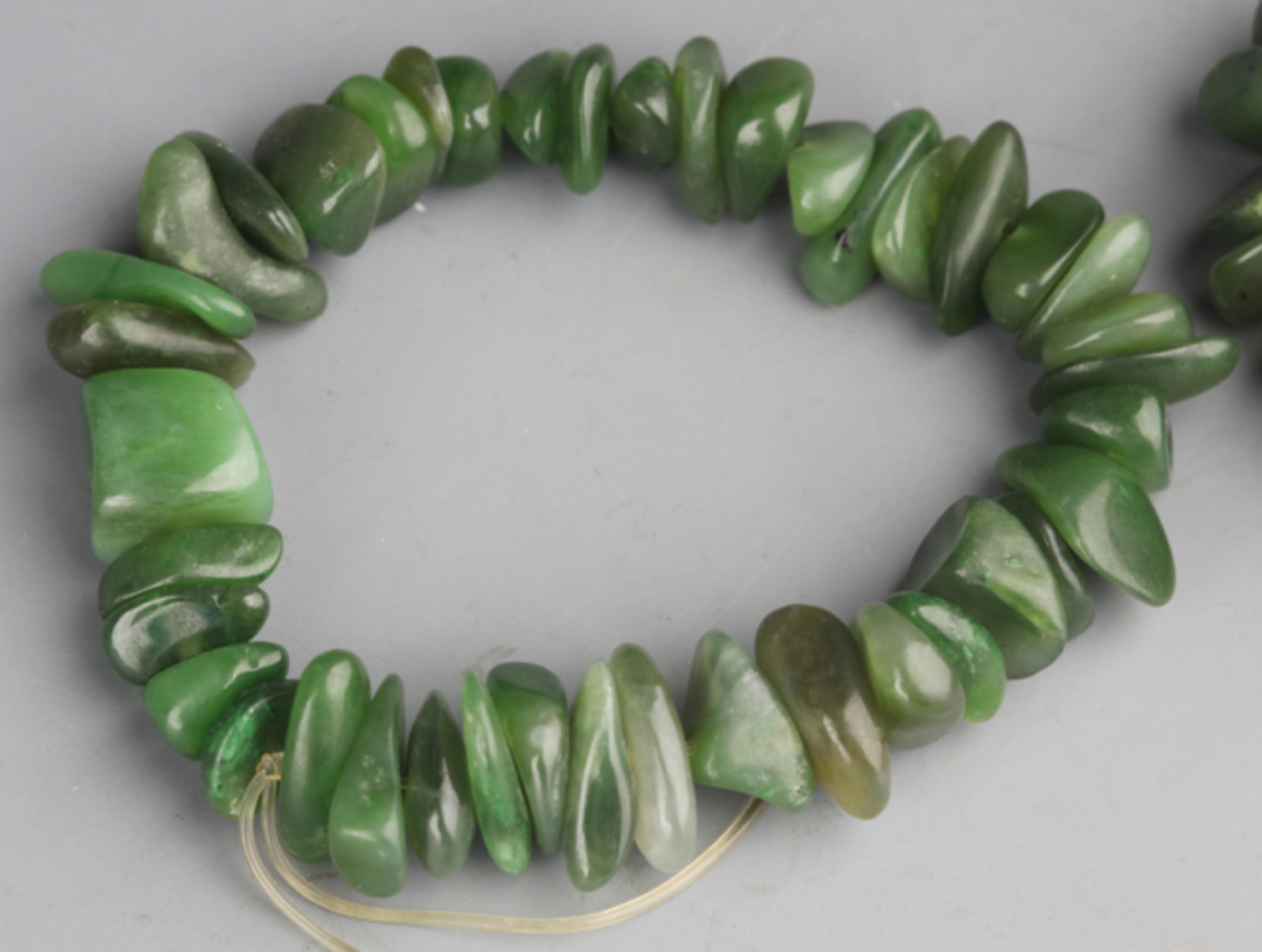 GROUP OF TWO FINE GREEN JADE BRACELETS: 20th Century; Long: 3.5 inch; . Wooden base for display only