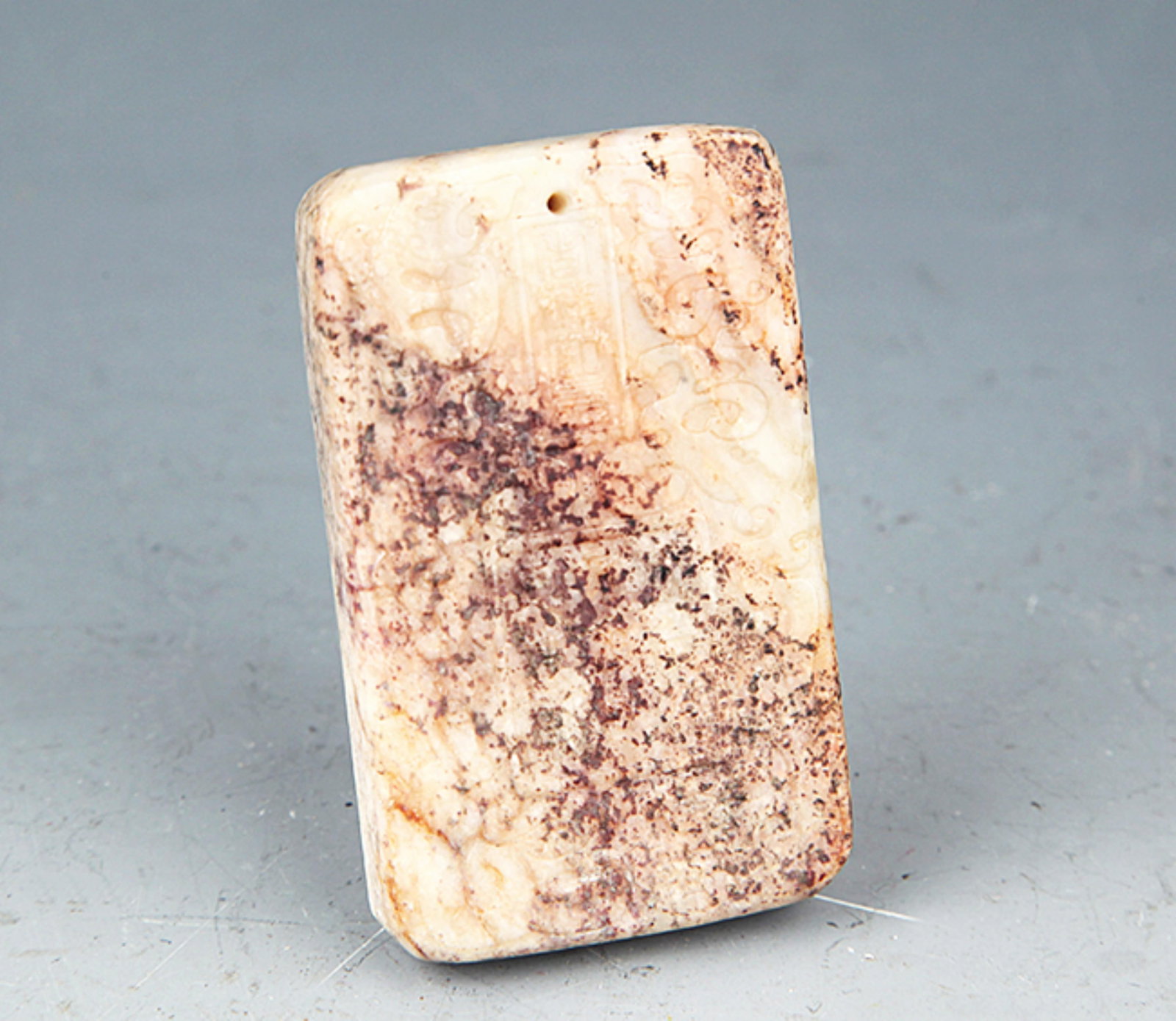 A FINELY CARVED WHITE JADE PENDANT: 20th Century; High: 2.25 inch; Width: 1.3 inch; . Wooden base for display only