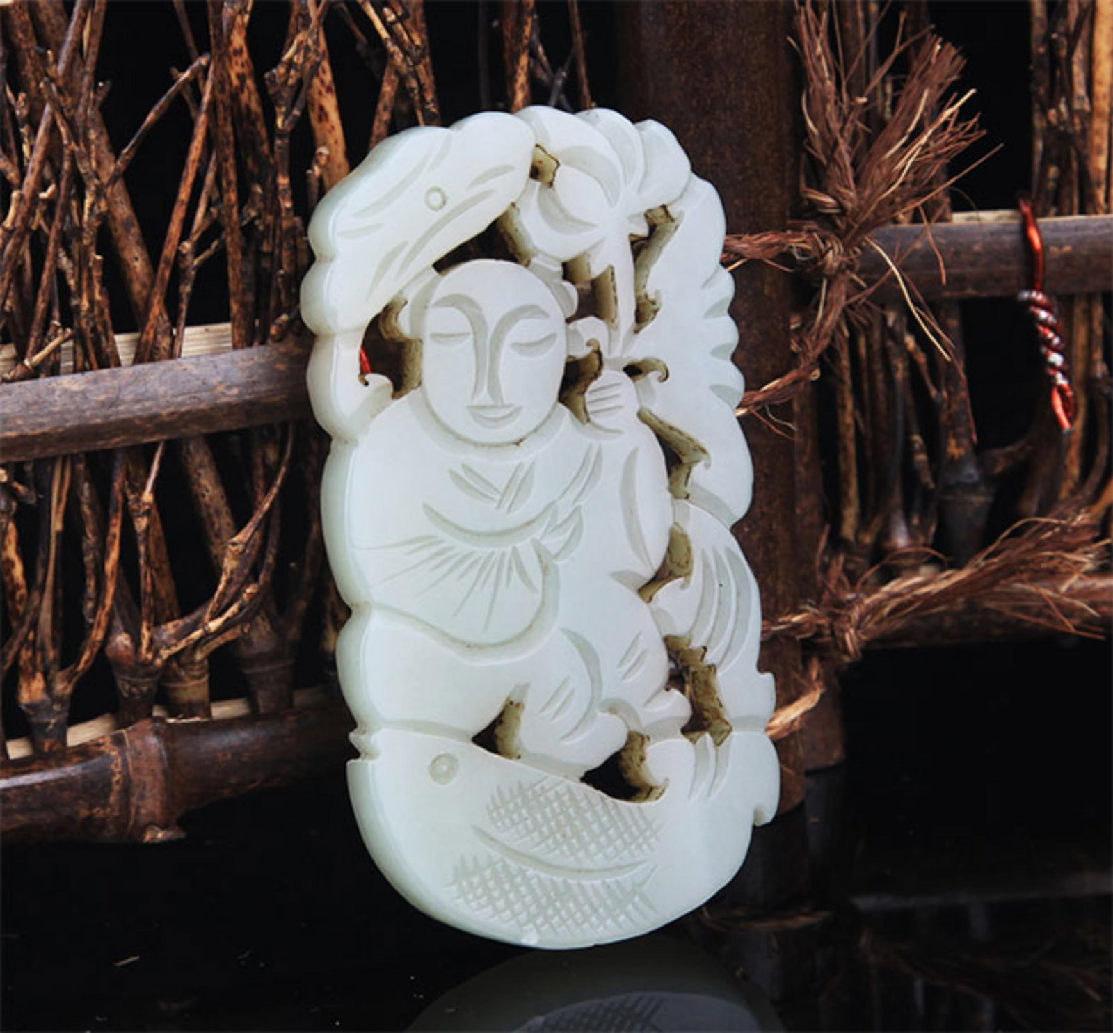 A FINE BOY WITH LOTUS FIGURE PALE CELADON JADE PENDANT: Modern; High: 3.0 inch; Width: 1.6 inch; . Wooden base for display only
