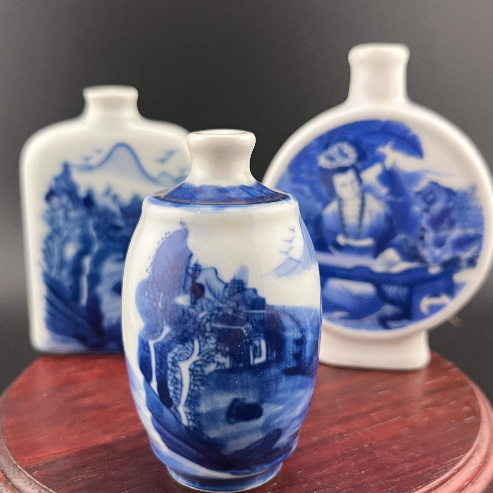 GROUP OF THREE BLUE AND WHITE SNUFF BOTTLES: Modern; High: 2.8 inch; Diameter: 1.6 inch; Long: 2 inch; Width: 0.75 inch; High: 3.02 inch; Long: 2.6 inch; Width: 0.77 inch; High: 3.5 inch; . Wooden base for display only
