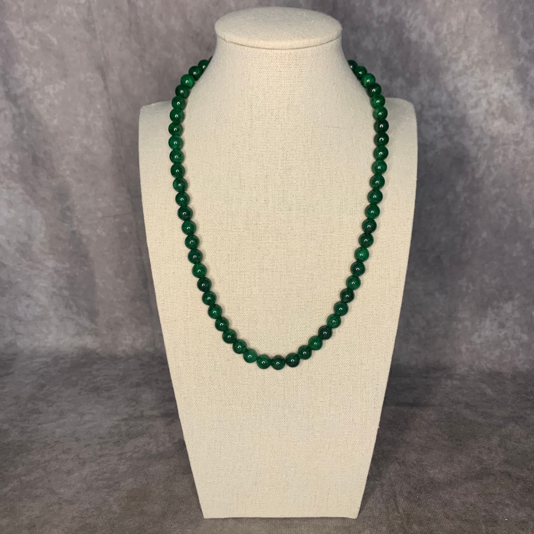 A FINE JADE MADE NECKLACE: Modern; Long: 9.5 inch; Each Bead Diameter: 0.3 inch. Wooden base for display only