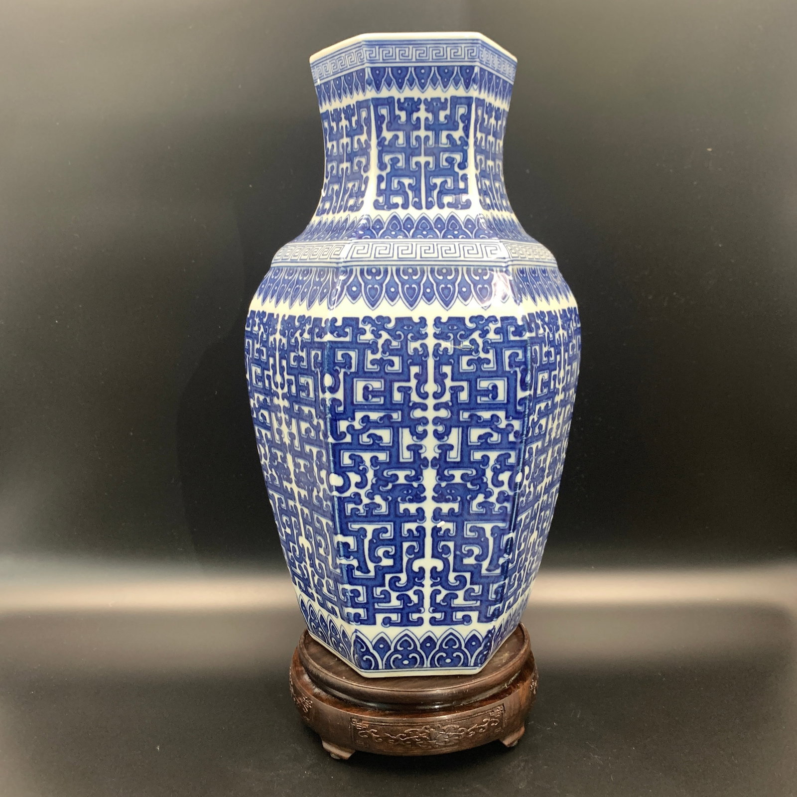 HEXAGONAL BLUE AND WHITE ARCHAISTIC VASE: Qing Dynasty; High: 15.2 inch; Diameter: 8.9 inch; . Wooden base for display only