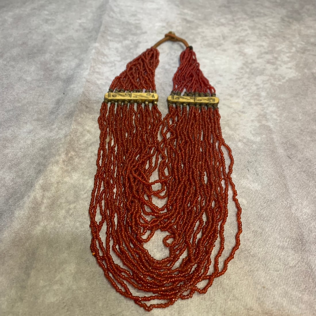 A FINE SMALL RED GLASS MADE NECKLACE: Modern; Long: 15.0 inch. Wooden base for display only