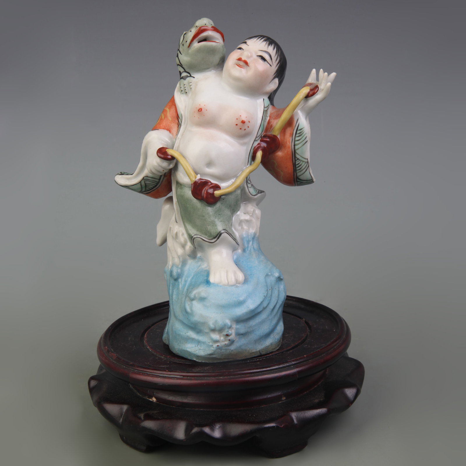 A FAMILLE ROSE LIU HAI AND THREE-LEGGED TOAD FIGURE: Republic Period; High: 6.1 inch; . Wooden base for display only