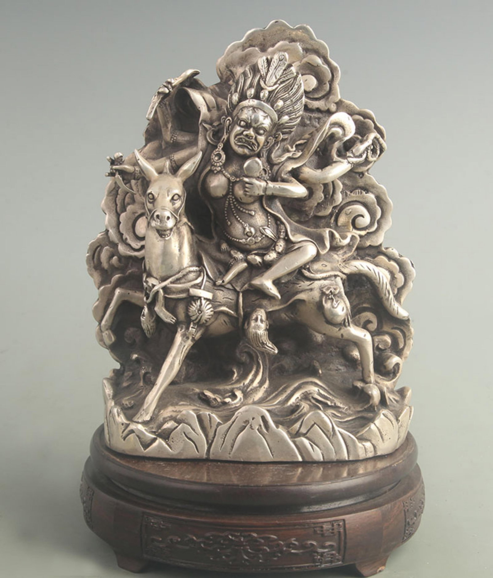 A SILVER-INLAID TIBETAN-STYLE PROTECTIVE DEITY: 19th Century; High: 7.90 inch; Width: 3.20 inch; Long: 5.80 inch. Wooden base for display only