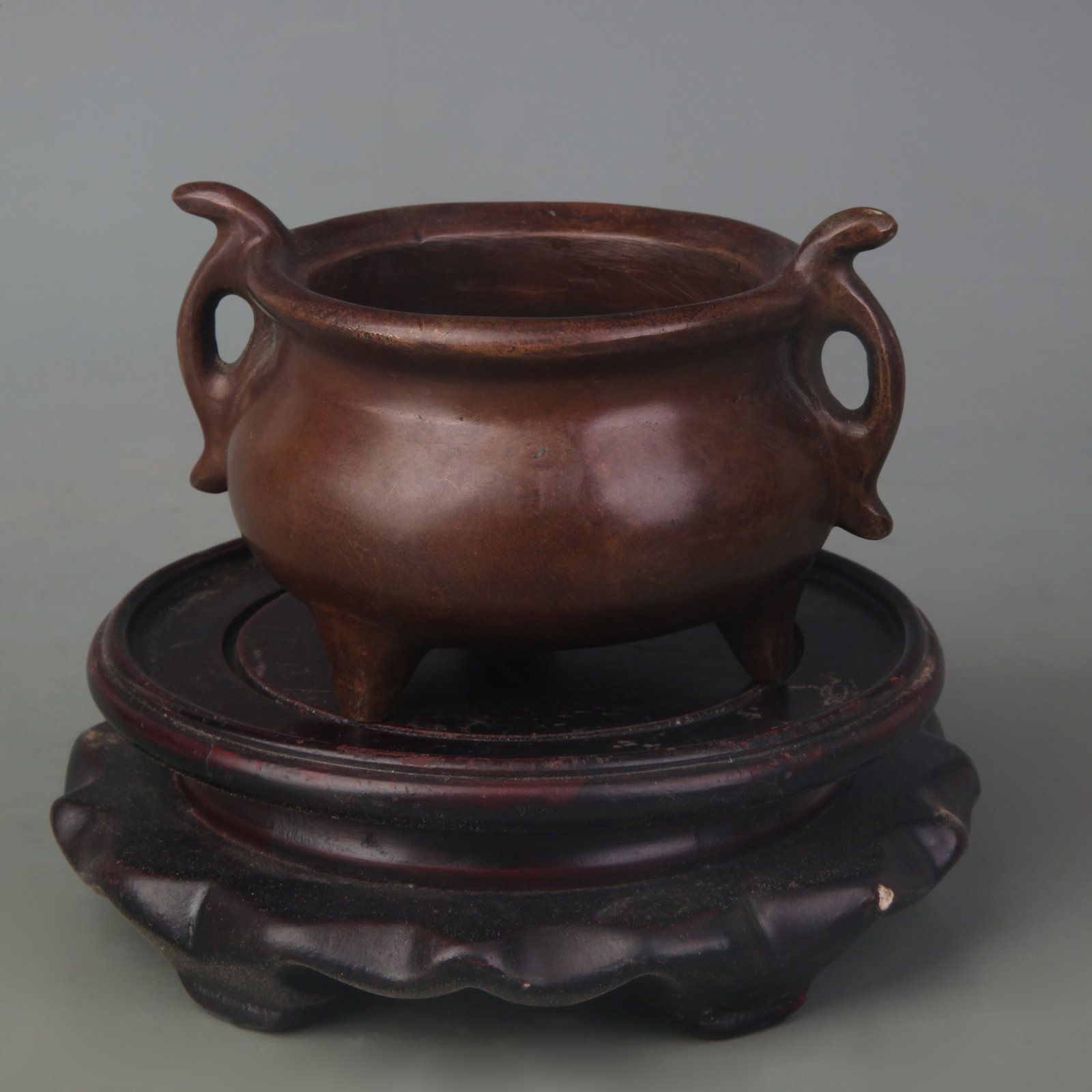 A BRONZE TRIPOD CENSER WITH FISH-FORM HANDLES: Qing Dynasty; Width: 3.9 inch; High: 2.6 inch. Wooden base for display only