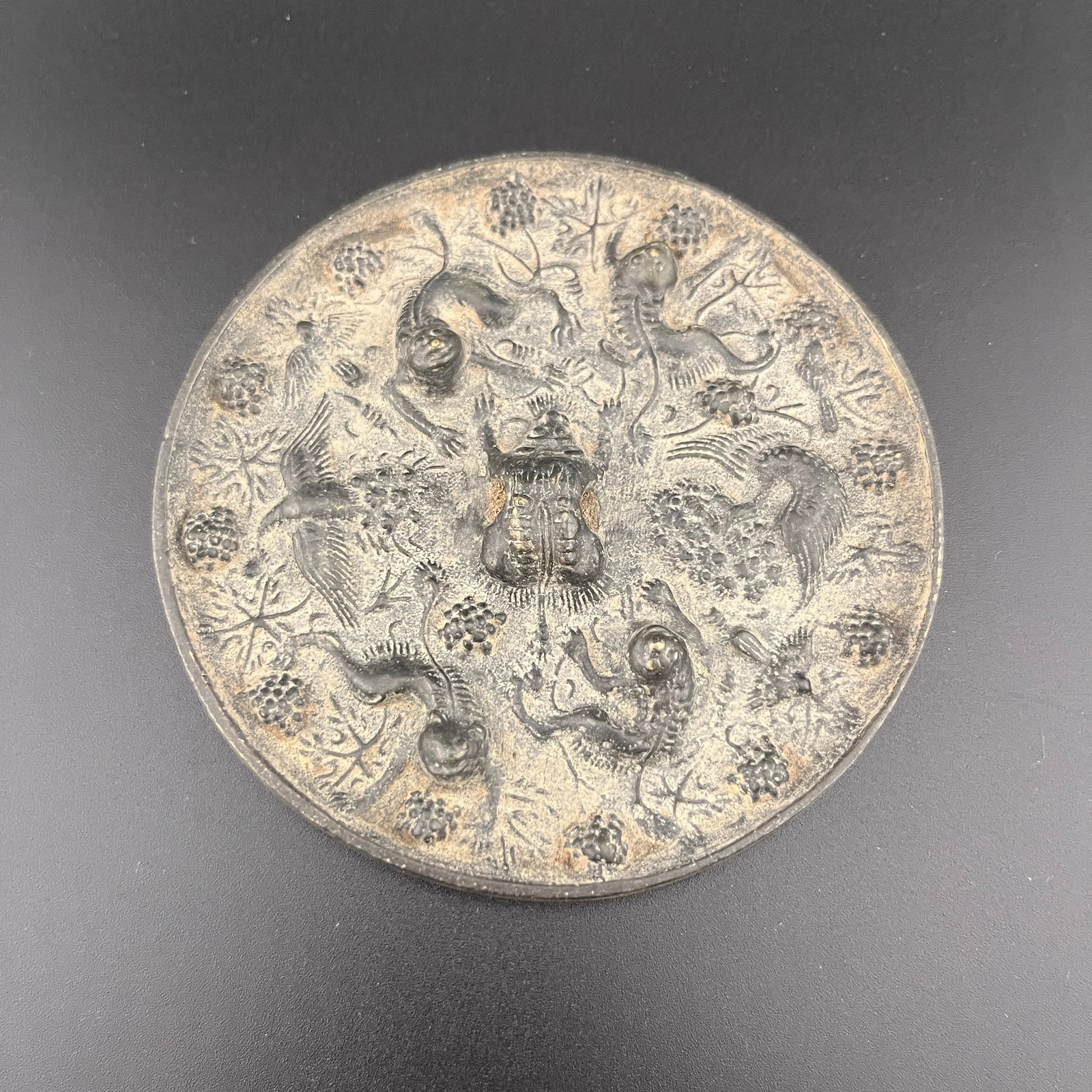 A FINE BRONZE "SEA BEAST AND GRAPE" MIRROR: Song Dynasty Style; High: 0.38 inch; Diameter: 3.78 inch; ;Wooden base for picture and display only.