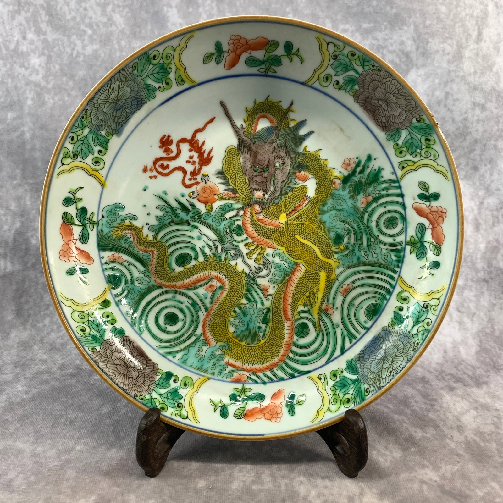 A FINE WUCAI FACING DRAGON AND SEA WAVES PORCELAIN PLATE: Ming Dynasty Style; High: 1.1 inch; Diameter: 10.2 inch; ;Wooden base for picture and display only.