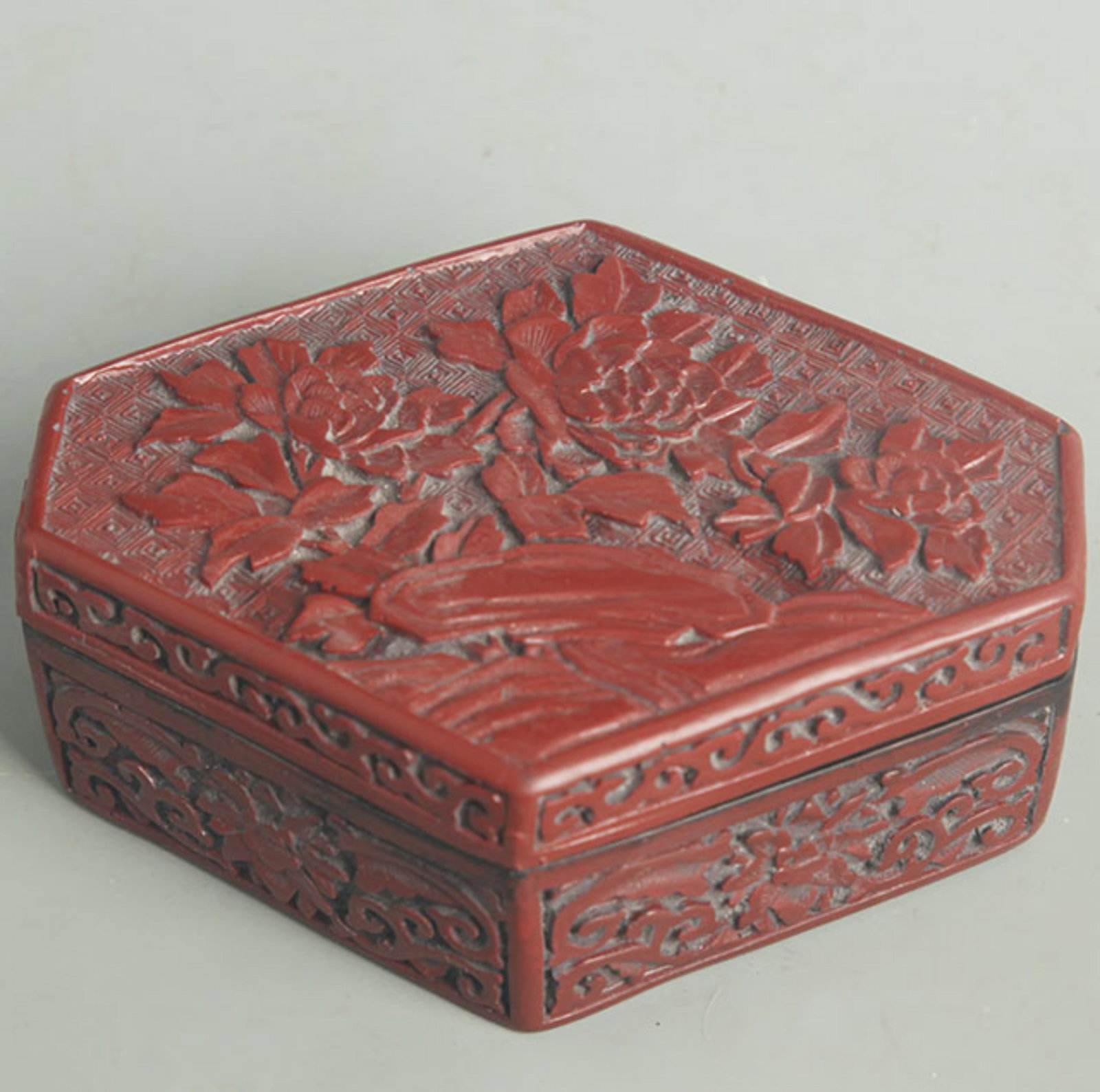 CARVED RED LACQUER HEXAGONAL FLORAL BOX: Qing Dynasty; High: 2.25 inch; Width: 5.00 inch; Long: 6.00 inch ;Wooden base for picture and display only.