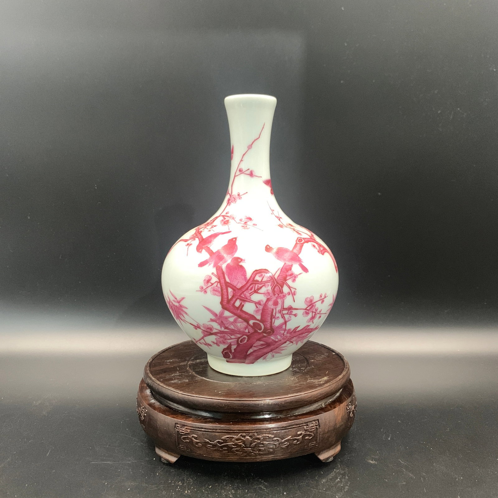 COPPER-RED GLAZED "BIRDS AND PLUM BLOSSOMS" BOTTLE VASE: Qing Dynasty; High: 7.9 inch; Diameter: 5.3 inch; ;Wooden base for picture and display only.