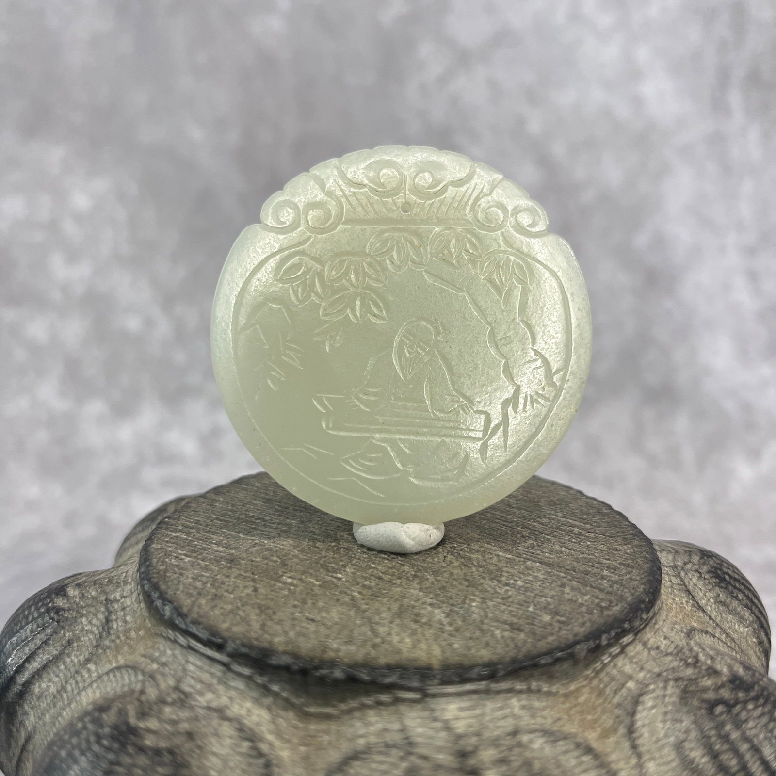 SCHOLAR PLAYING THE GUQIN CIRCULAR PENDANT: Republic Period; High: 0.23 inch; Diameter: 2.1 inch; ;Wooden base for picture and display only.