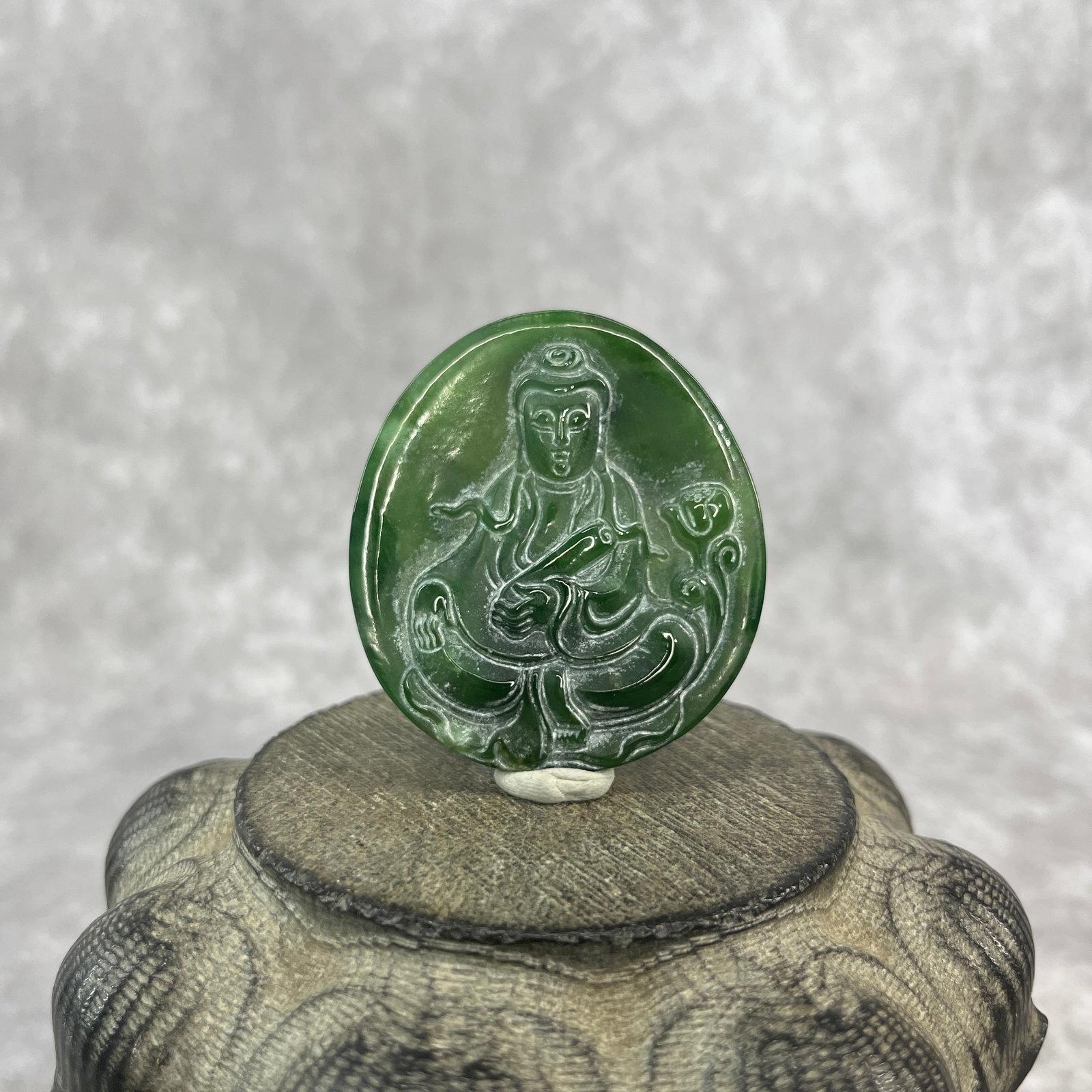 A FINE HETIAN GREEN JADE IN FIGURE OF GUAN YIN: Qing Dynasty; Long: 2.12 inch; Width: 1.92 inch; High: 0.3 inch; ;Wooden base for picture and display only.