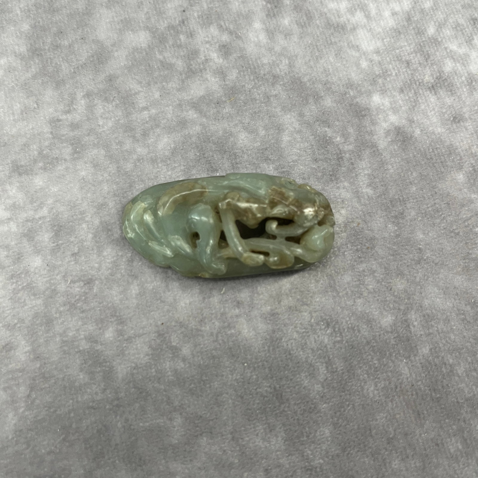 A FINE HETIAN JADE CARVING IN FIGURE OF QI DRAGON: Qing Dynasty; Long: 2.03 inch; Width: 1 inch; High: 0.6 inch; ;Wooden base for picture and display only.