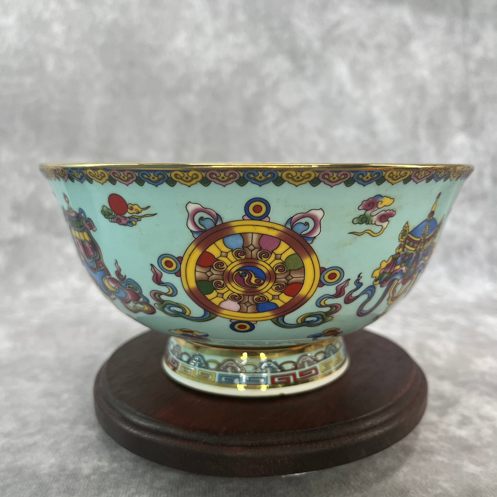 FAMILLE ROSE "EIGHT AUSPICIOUS SYMBOLS" PORCELAIN BOWL: Qing Dynasty; High: 3 inch; Diameter: 6.2 inch; ;Wooden base for picture and display only.
