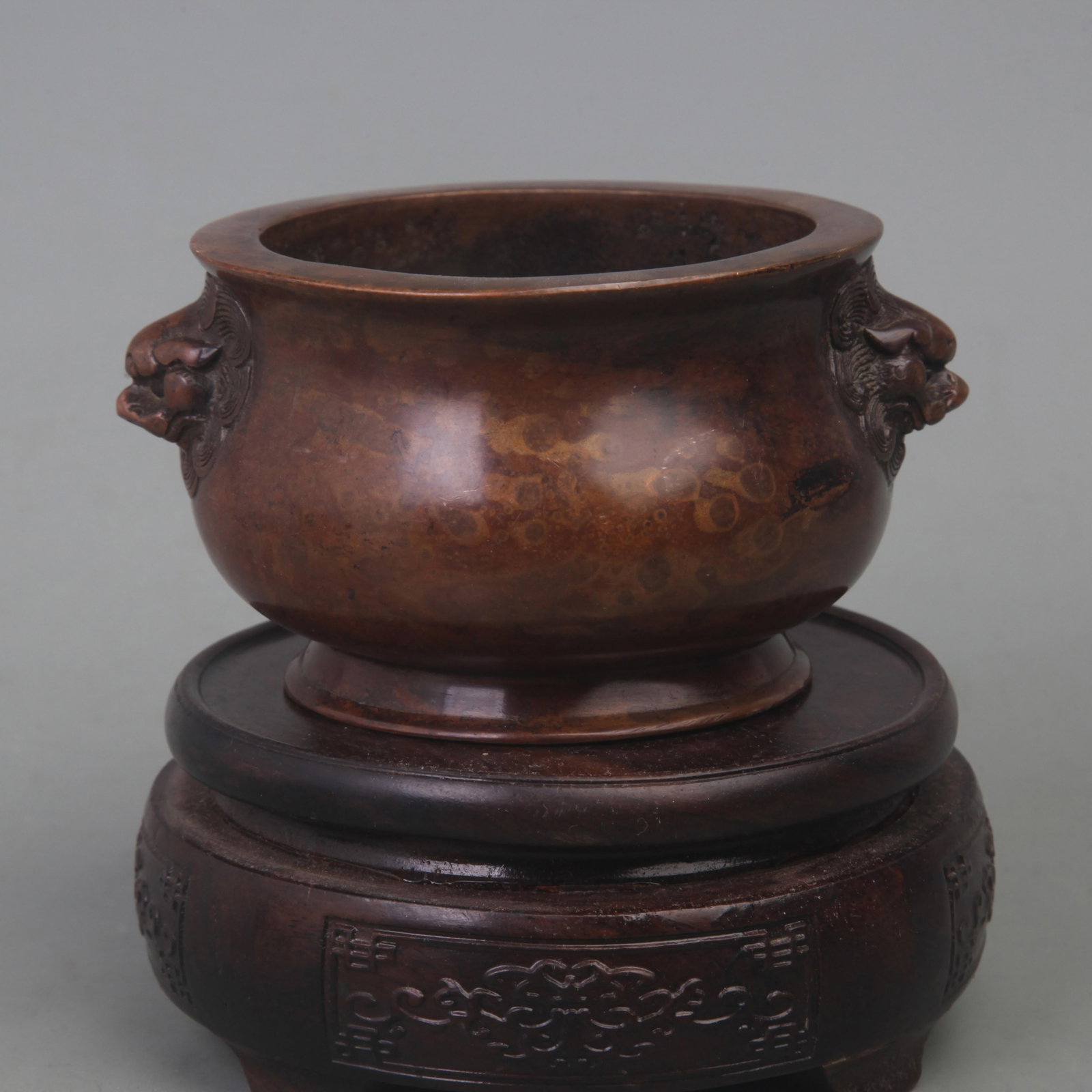A BRONZE LION-EAR ROUND-FOOTED CENSER: Ming Dynasty Style; Diameter: 4.5 inch; High: 2.5 inch; ;Wooden base for picture and display only.