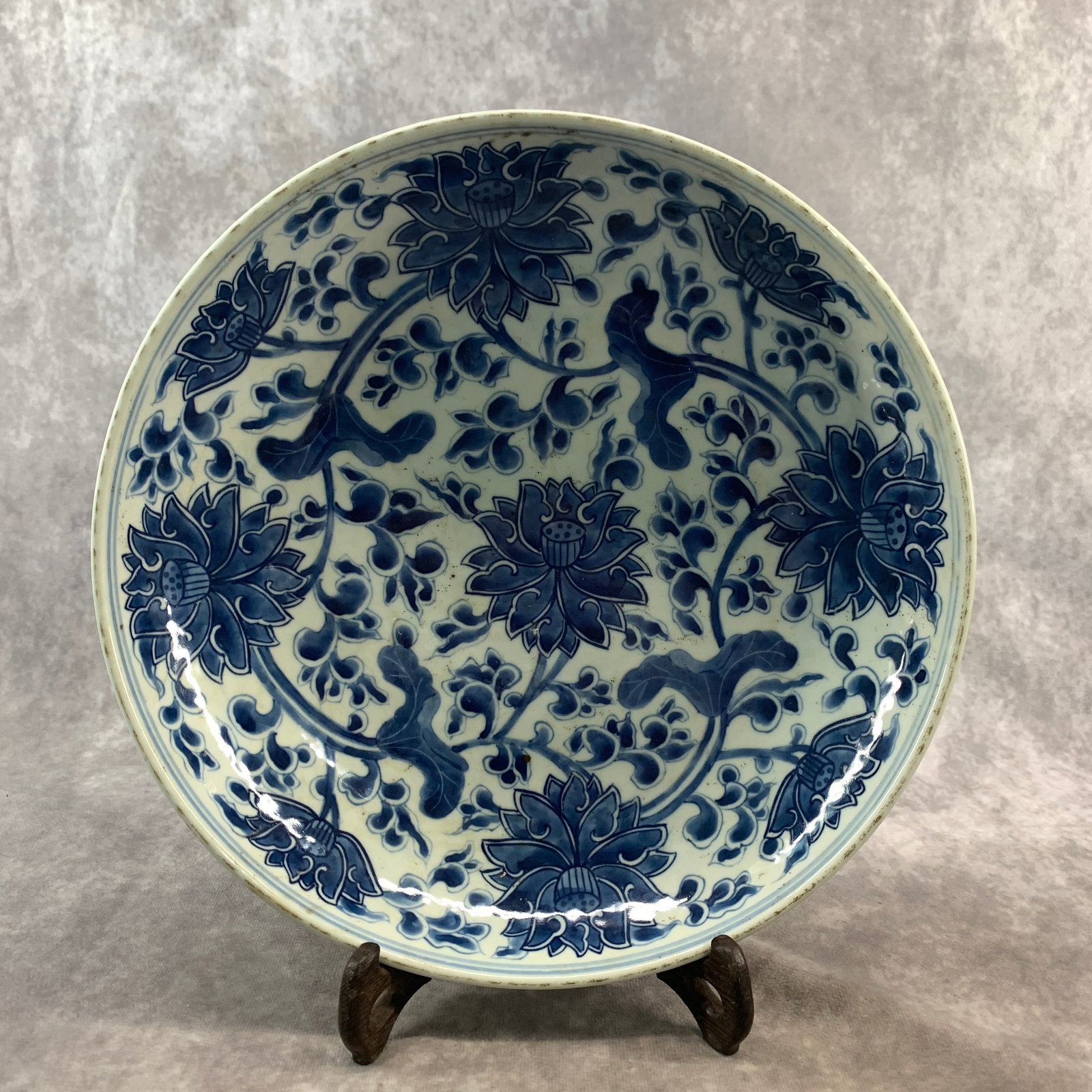 BLUE AND WHITE INTERLOCKING LOTUS PATTERN PORCELAIN PLATE: Qing Dynasty; High: 1.8 inch; Diameter: 9.3 inch; ;Wooden base for picture and display only.