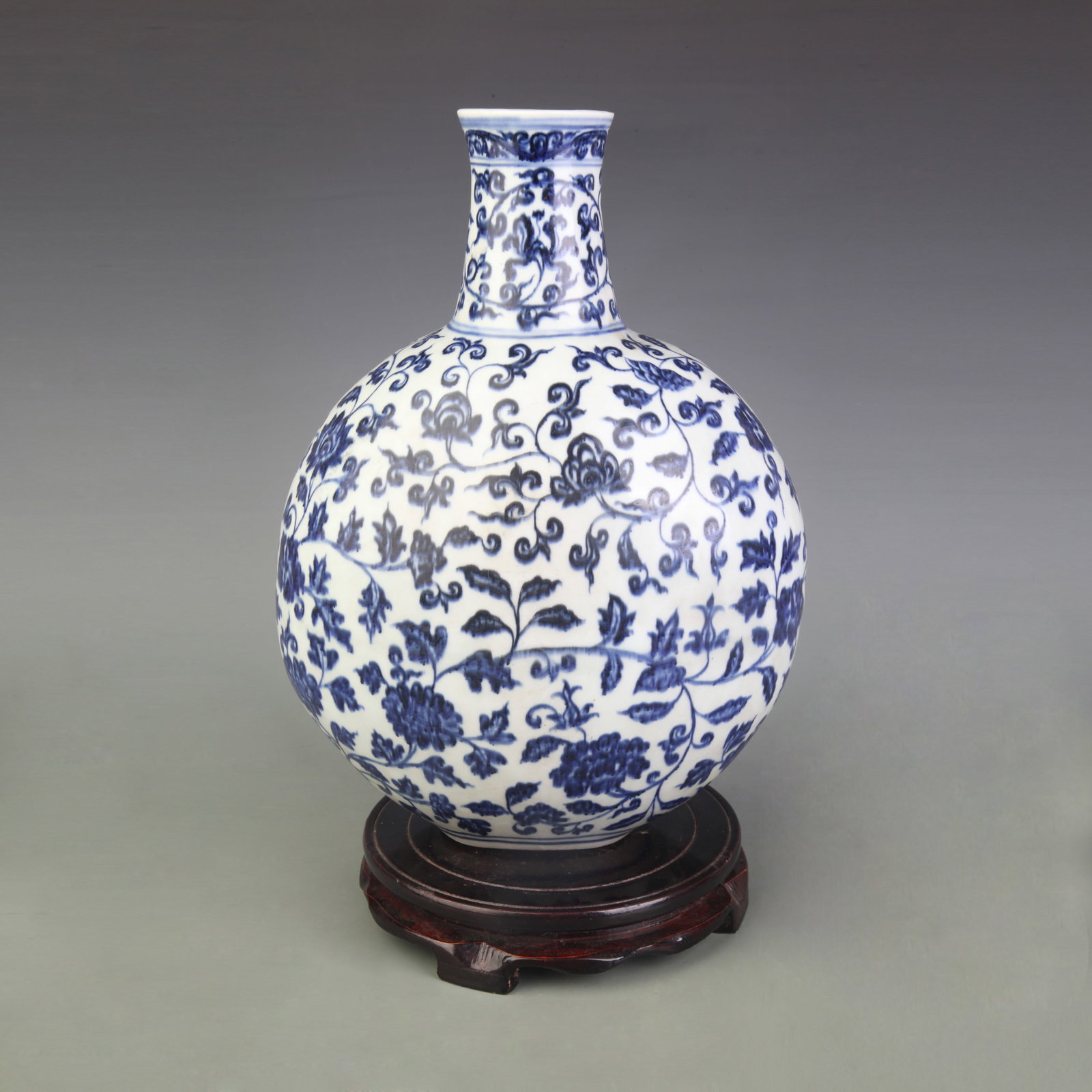 BLUE AND WHITE PORCELAIN MOON FLASK WITH FLORAL DECORATION: Ming Dynasty Xuan De Style; Width: 8.6inch; High: 12.4inch;;Wooden base for picture and display only.