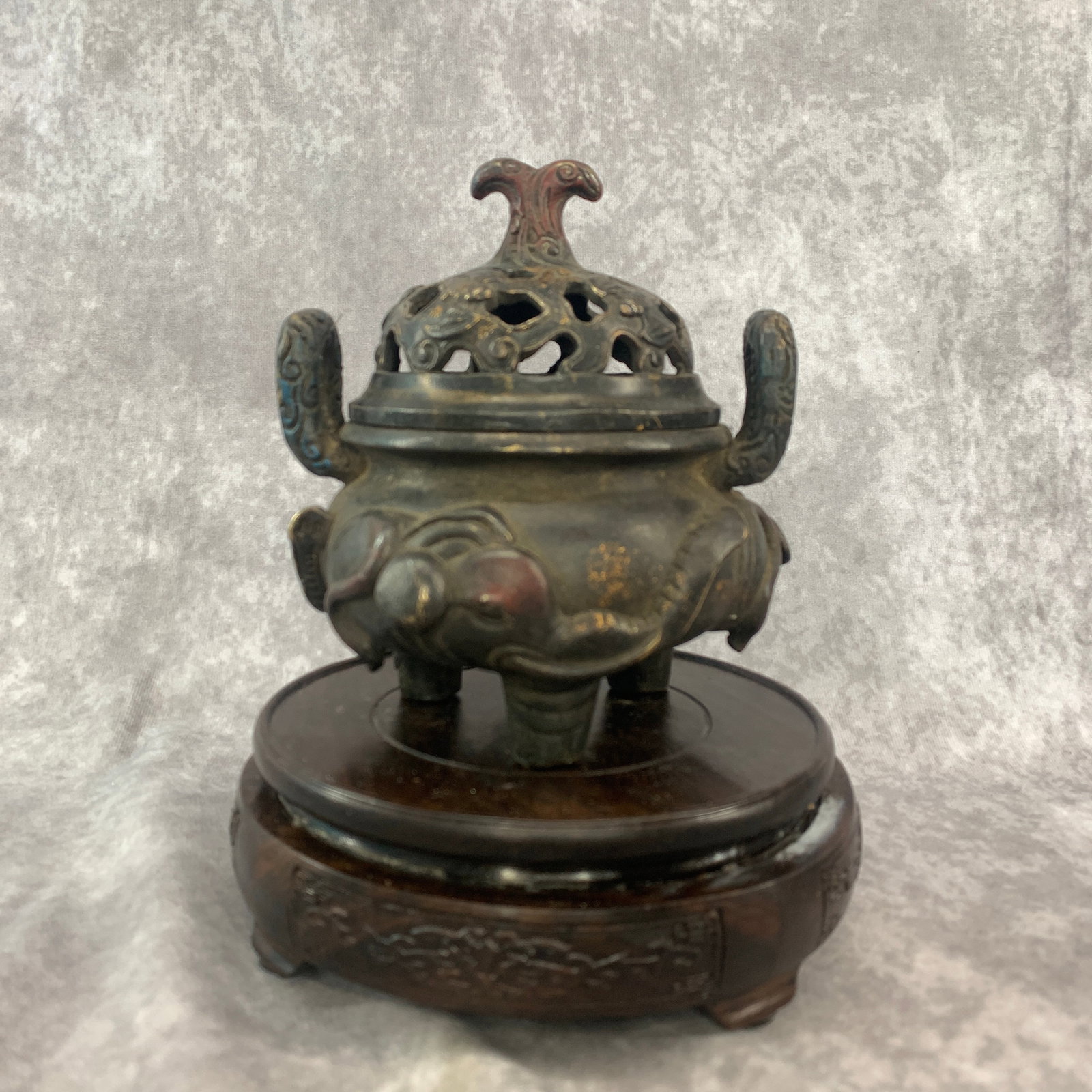 GILT-BRONZE ELEPHANT-MASK TRIPOD INCENSE BURNER: Qing Dynasty; Long: 5.1 inch; Width: 5.1 inch; High: 5.6 inch; ;Wooden base for picture and display only.