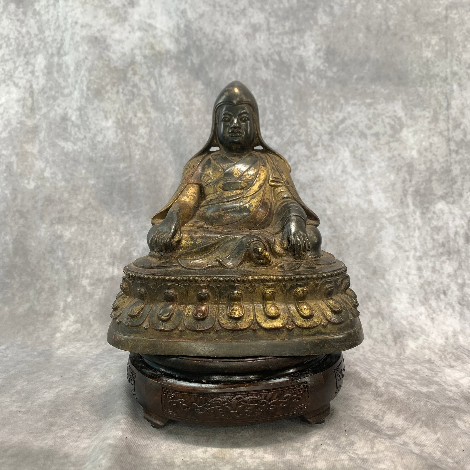 GILT-BRONZE SEATED TIBETAN LAMA FIGURE ON LOTUS THRONE: Ming Dynasty Style; Long: 7.6 inch; Width: 5.5 inch; High: 8 inch; ;Wooden base for picture and display only.