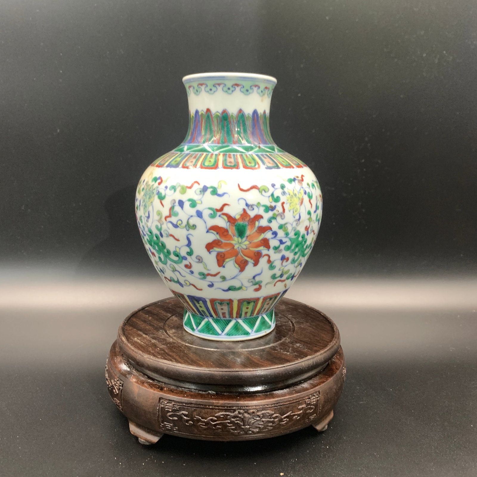 WUCAI INTERLOCKING LOTUS AND PLANTAIN LEAF PATTERN VASE: Qing Dynasty; High: 6.6 inch; Diameter: 5 inch; ;Wooden base for picture and display only.