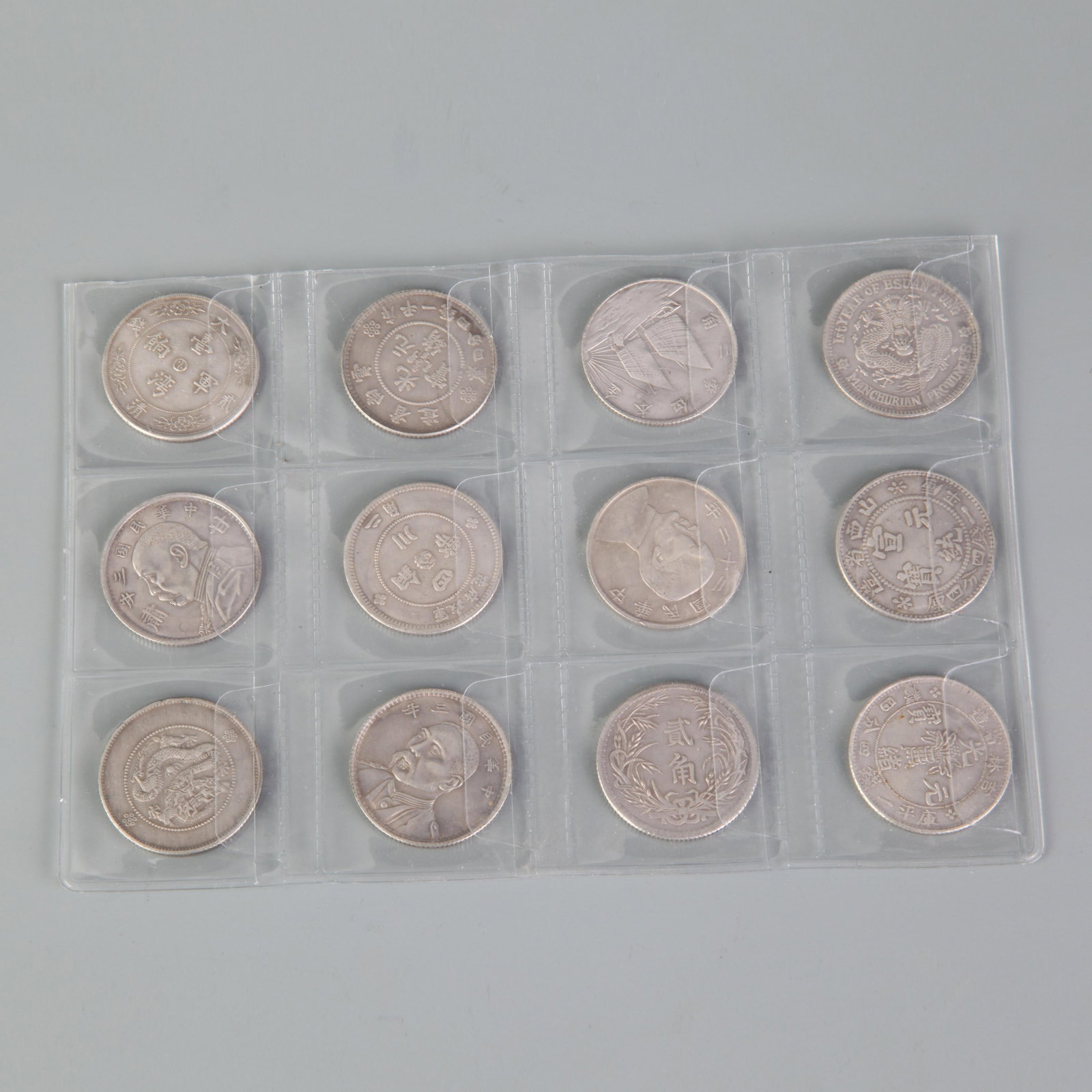 GROUP OF TWELVE REPUBLIC OF CHINA DOLLARS: Republic Period; Diameter: 1.0 inch ;Wooden base for picture and display only.