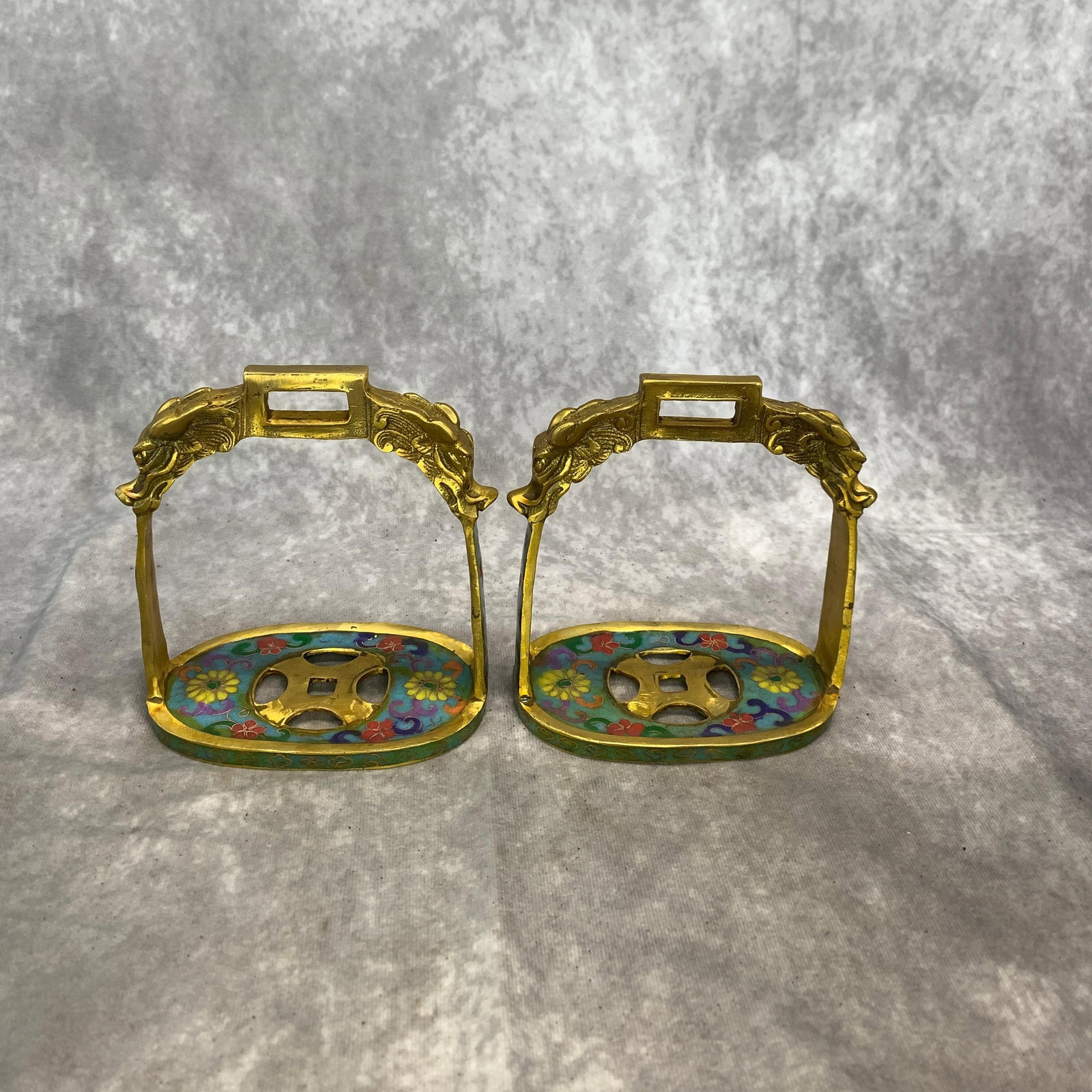PAIR OF CLOISONNE ENAMEL AND BRASS DRAGON-HEAD HORSE STIRRUPS: Qing Dynasty; Long: 5.1 inch; Width: 2.4 inch; High: 5.6 inch; ;Wooden base for picture and display only.