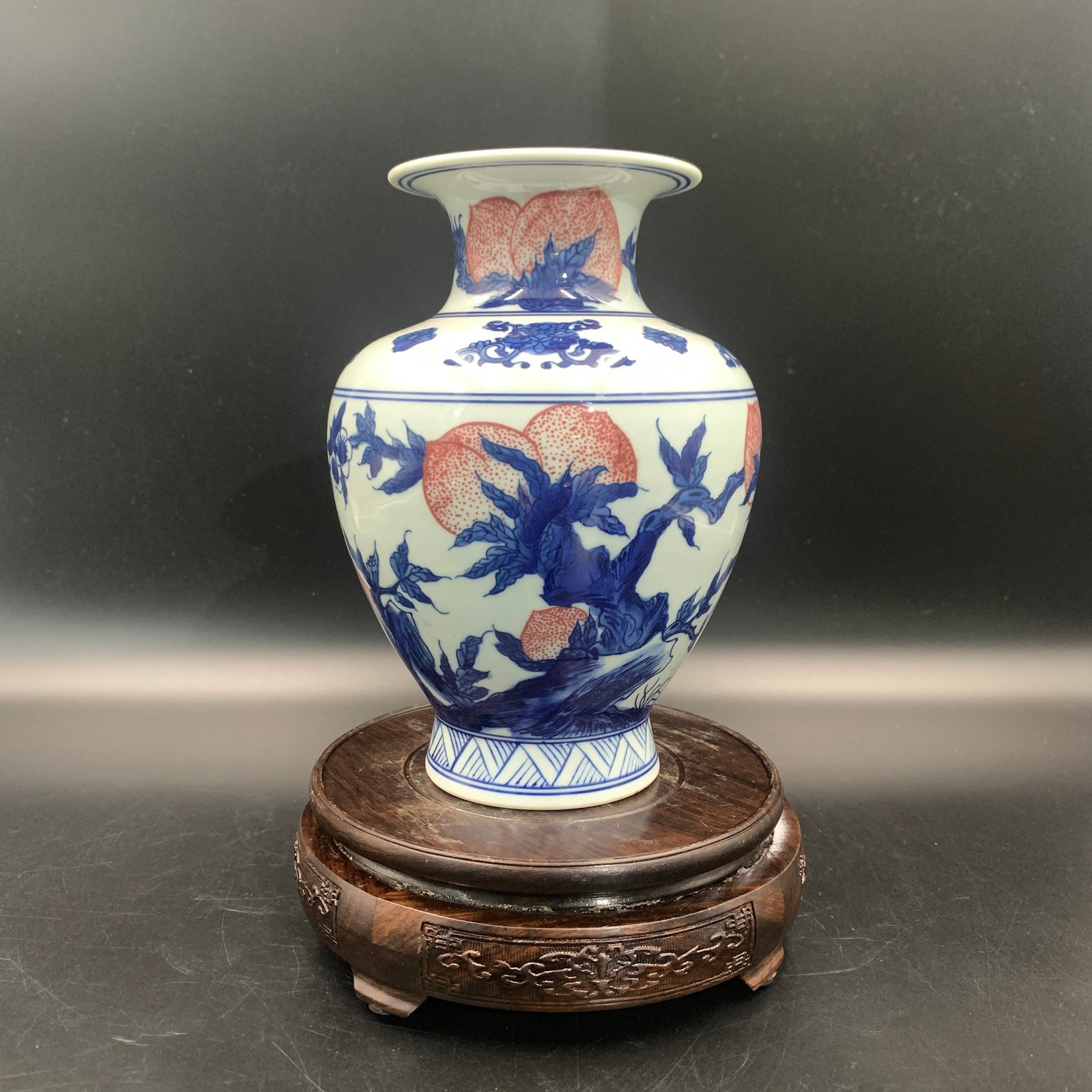 BLUE AND WHITE AND COPPER-RED 'NINE PEACHES' VASE: Qing Dynasty; High: 7.5 inch; Diameter: 5.4 inch; ;Wooden base for picture and display only.