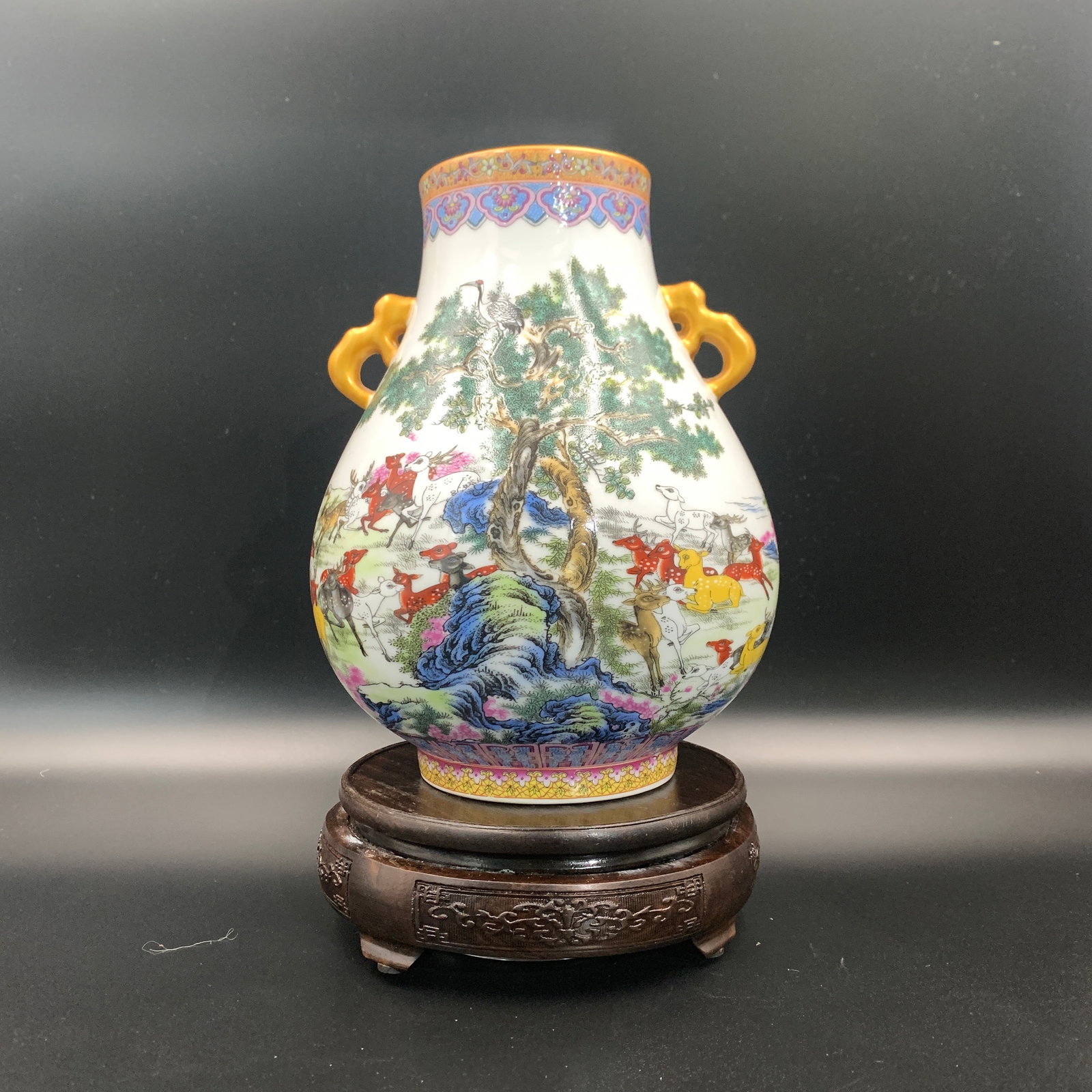 A FAMILLE-ROSE 'HUNDRED DEER' PORCELAIN VASE WITH GILT HANDLES: Qing Dynasty; High: 9 inch; Diameter: 7.1 inch; ;Wooden base for picture and display only.