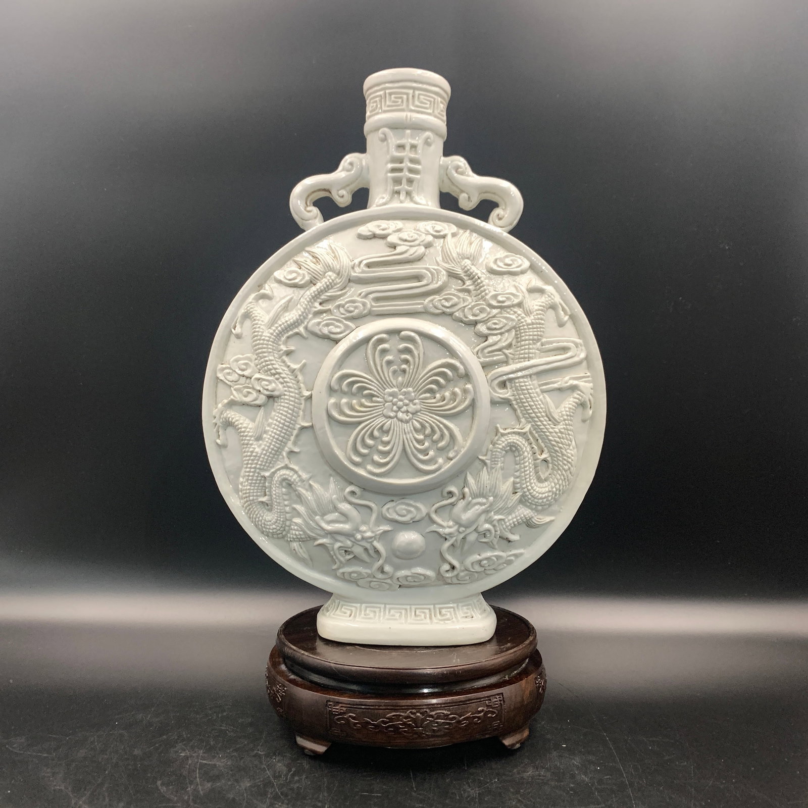 A CELADON-GLAZED RELIEF-CARVED 'DRAGON' MOONFLASK (BAOYUEPING): Ming Dynasty Style; Long: 9.2 inch; Width: 4.9 inch; High: 13.3 inch; ;Wooden base for picture and display only.