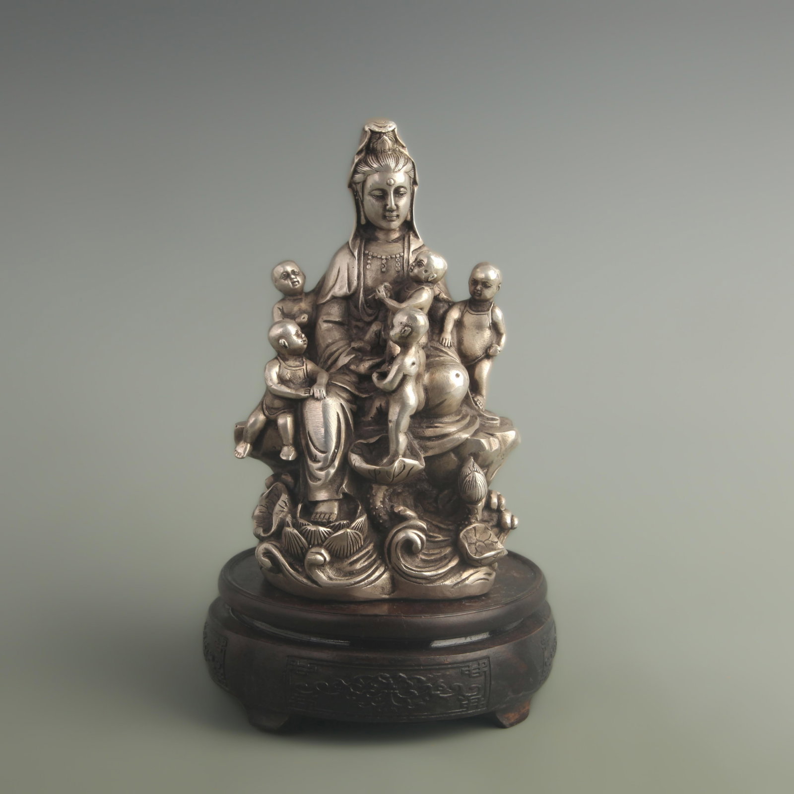 A SILVERED BRONZE FIGURE OF CHILD-GIVING GUANYIN: Qing Dynasty Qian Long Period; High: 7.00 inch; Width: 3.20 inch; Long: 3.90 inch ;Wooden base for picture and display only.