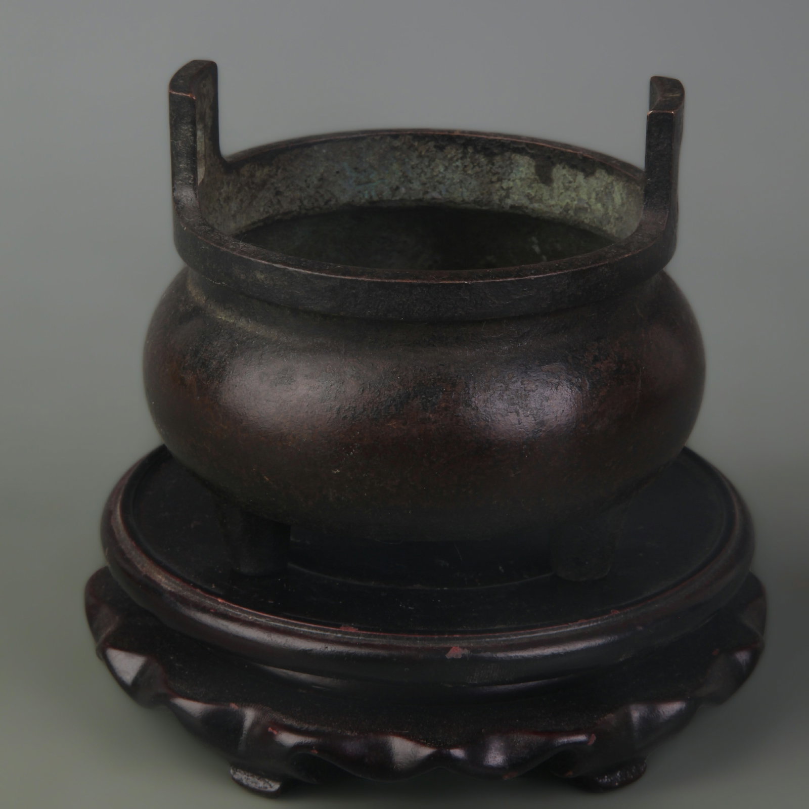 A FINE DOUBLE-EARED THREE-LEGGED INCENSE BURNER: Qing Dynasty Qian Long Period; Width: 3.6 inch High: 3.4 inch . Wooden base for display only