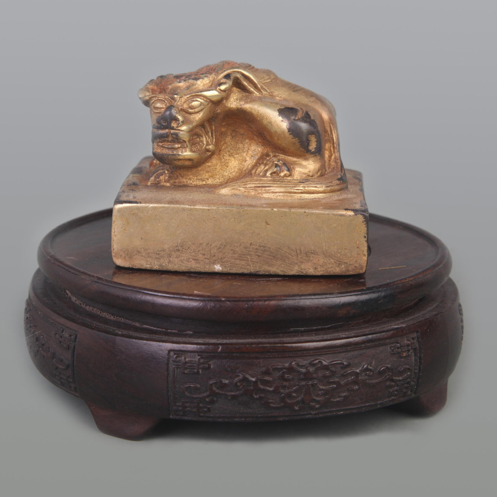 A GILT BRONZE SQUARE SEAL WITH BEAST-HEAD FINIAL: Qing Dynasty; Diameter: 3.0 inch; High: 2.3 inch; . Wooden base for display only