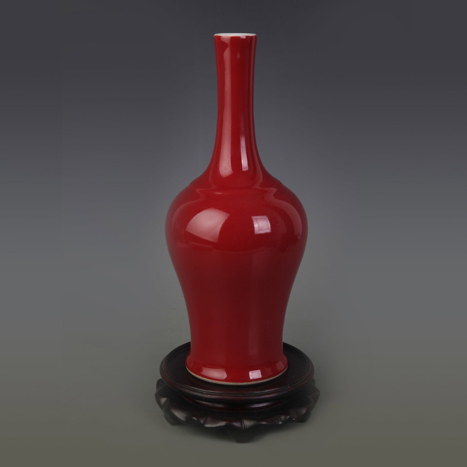 A RED GLAZED LONG-NECK PORCELAIN VASE: Qing Dynasty Qian Long Period; Diameter: 3.2 inch; High: 10.2 inch. Wooden base for display only