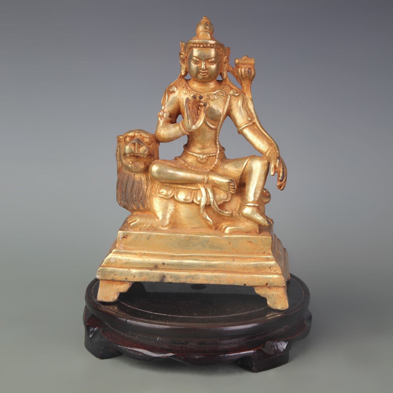 TIBETAN-STYLE GILT BRONZE STATUE OF MANJUSHRI SIMHANADA: Qing Dynasty; Width: 5.5 inch; High: 8.0 inch. Wooden base for display only