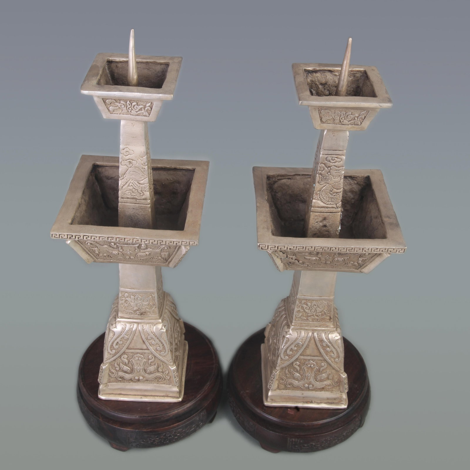 RARE PAIR OF WHITE BRONZE DRAGON PATTERN CANDLESTICKS: Qing Dynasty; Diameter: 4.5 inch; High: 13.6 inch; . Wooden base for display only