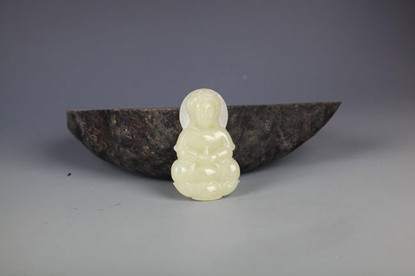 A FINELY CARVED HETIAN JADE IN FIGURE OF GUANYIN: Modern; High: 2.25 inch Width: 1.25 inch . Wooden base for display only