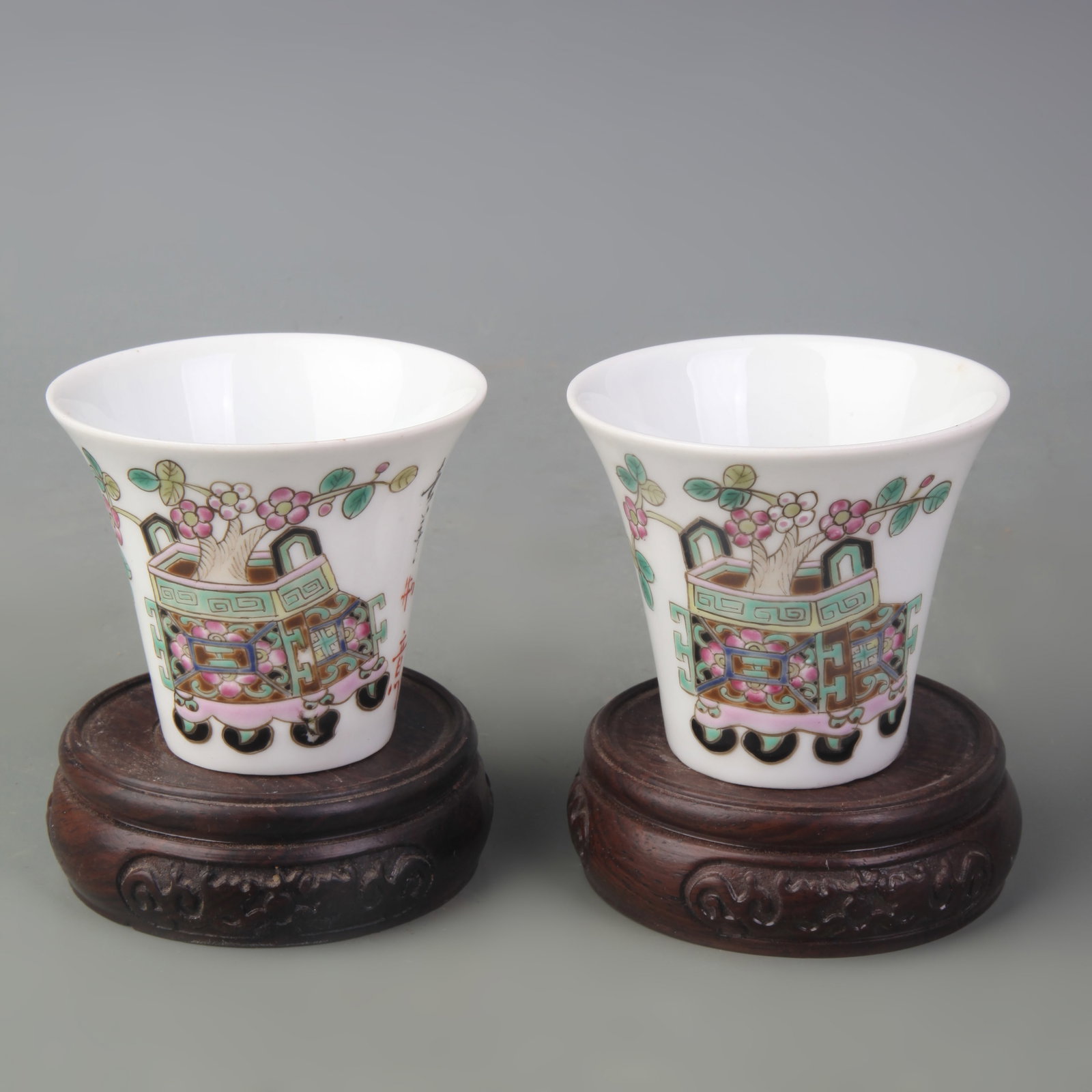 A PAIR OF FAMILLE ROSE TEACUPS WITH ZHONG DING MOTIF: Republic Period; Diameter: 2.9 inch; High: 2.5 inch; . Wooden base for display only
