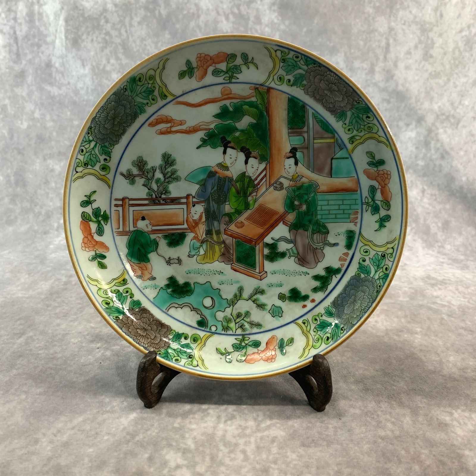 FAMILLE VERTE "LADIES IN A GARDEN" PORCELAIN PLATE: Republic Period; High: 1.1 inch; Diameter: 10.2 inch; . Wooden base for display only