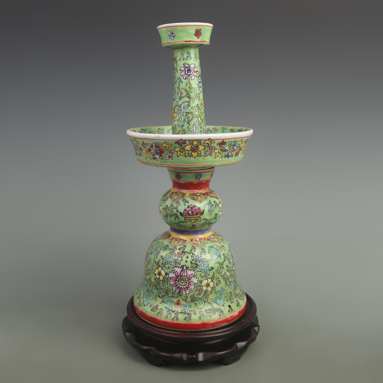 A GREEN GROUND FLOWER PATTERN PORCELAIN CANDLESTICKS: Qing Dynasty Qian Long Period; High: 15.5 inch; Width: 6.5 inch; . Wooden base for display only