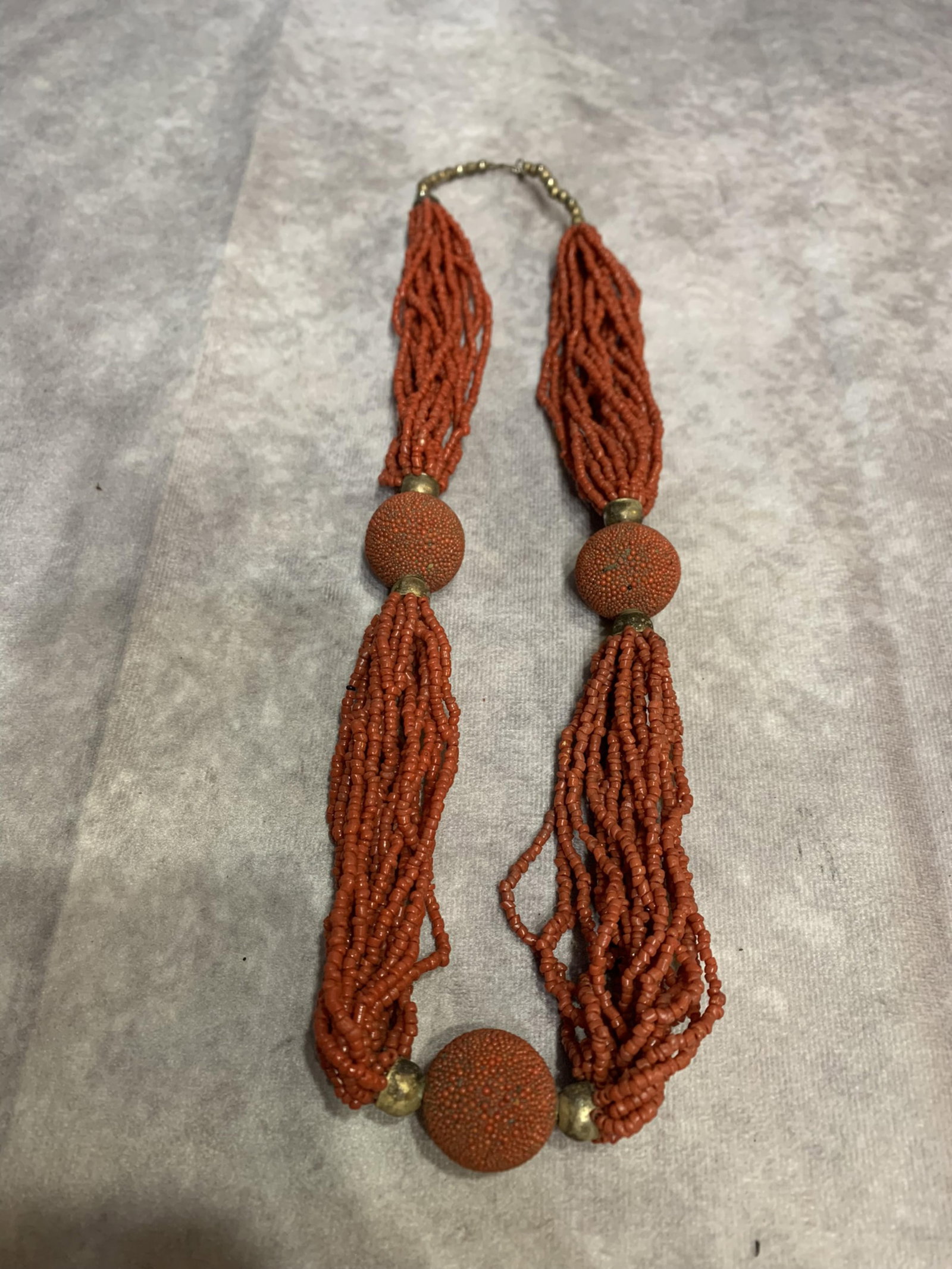 A FINE SMALL RED CORAL MADE NECKLACE: Modern; Long: 12.0 inch. Wooden base for display only