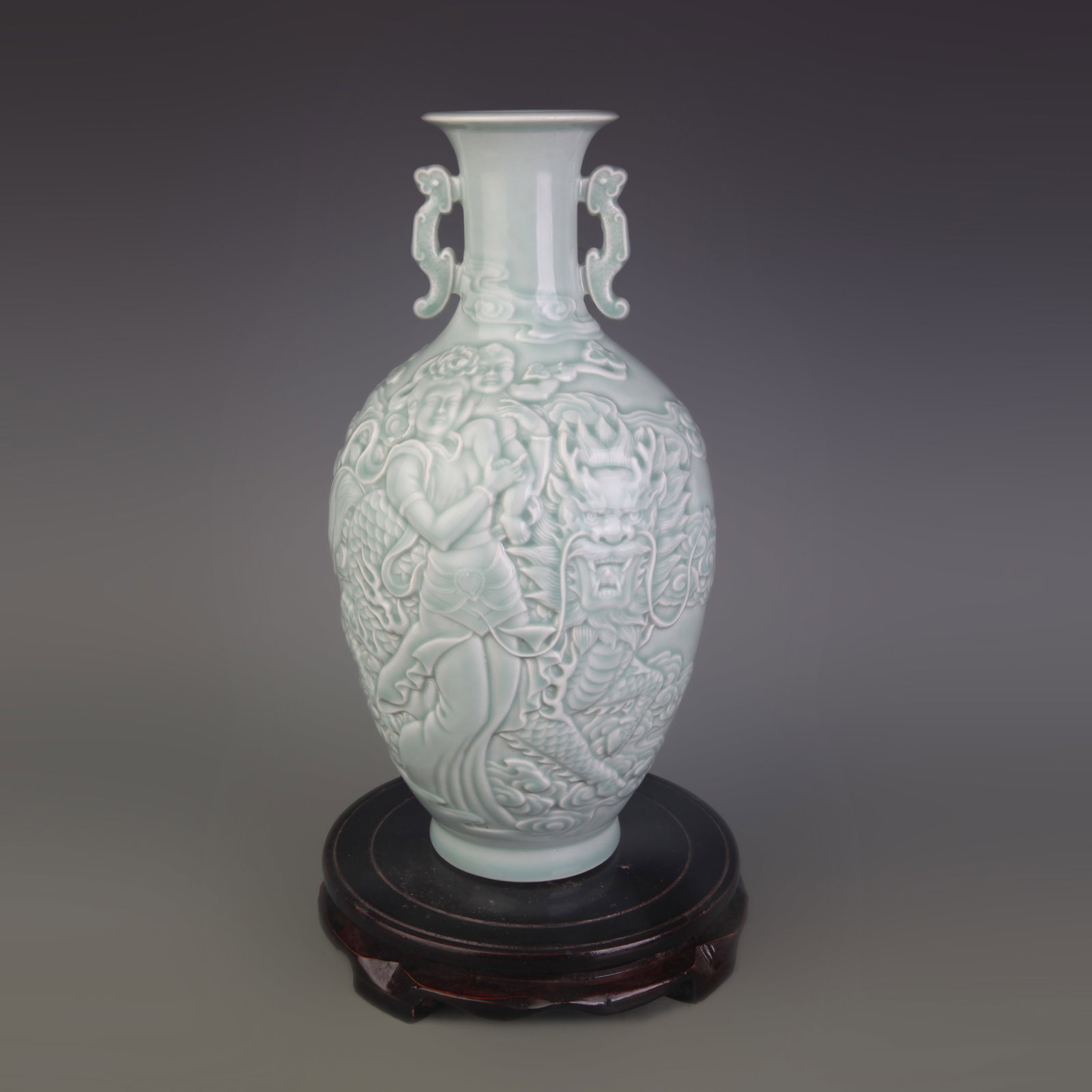 CELADON COLOR DOUBLE-EAR PORCELAIN VASE WITH CARVED HUMAN FIGURES: Qing Dynasty Qian Long Period; Diameter: 3.1 inch; High: 11.4 inch. Wooden base for display only