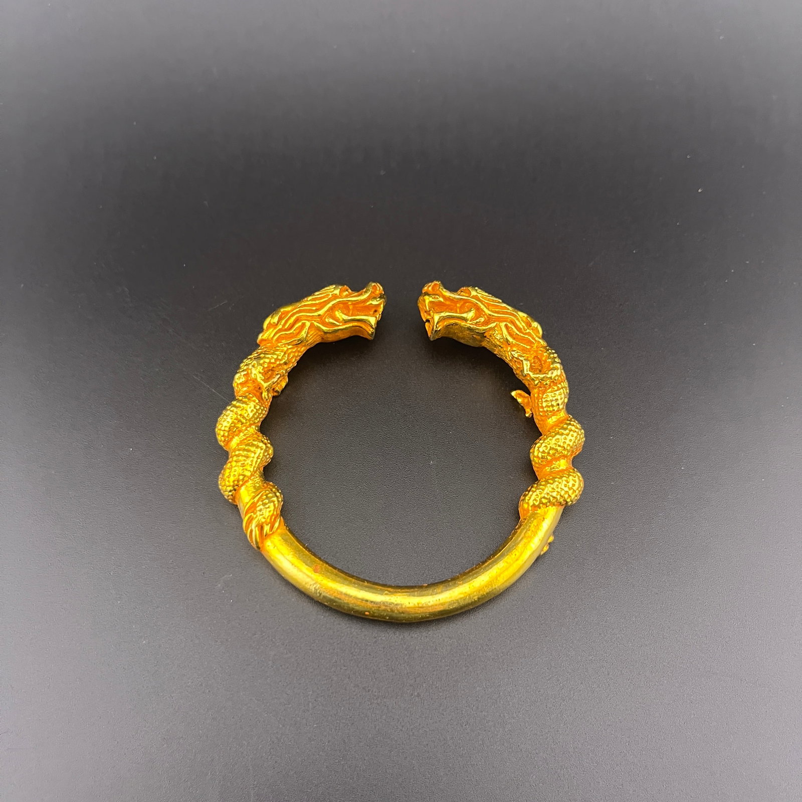 GILT DRAGON-HEAD OPEN TORC BRACELET: Modern; Diameter: 2.22 inch; . Wooden base for display only
