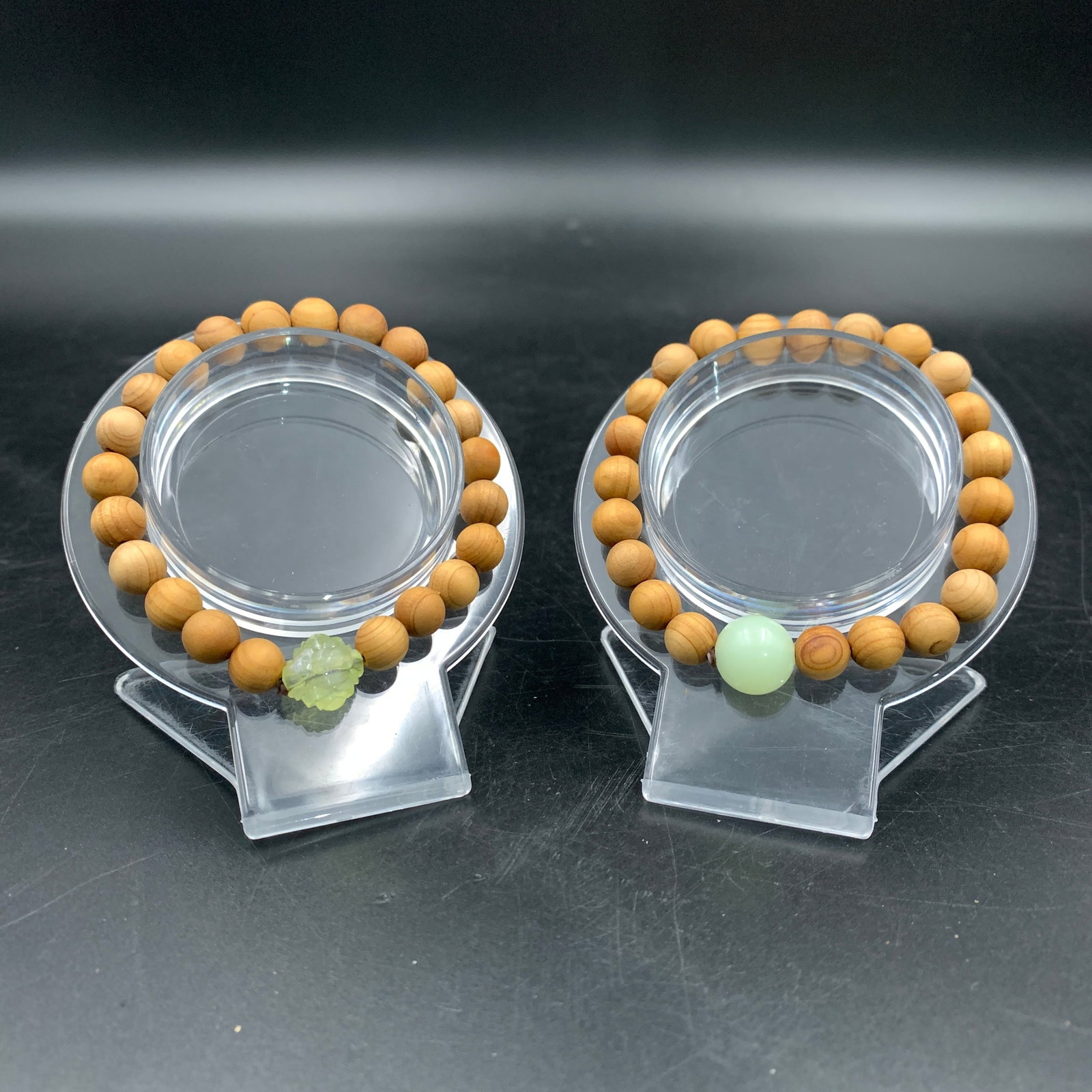 PAIR OF CEDAR WOOD BEAD BRACELETS: Modern; Long: 3.4 inch; Diameter: 0.4 inch; . Wooden base for display only