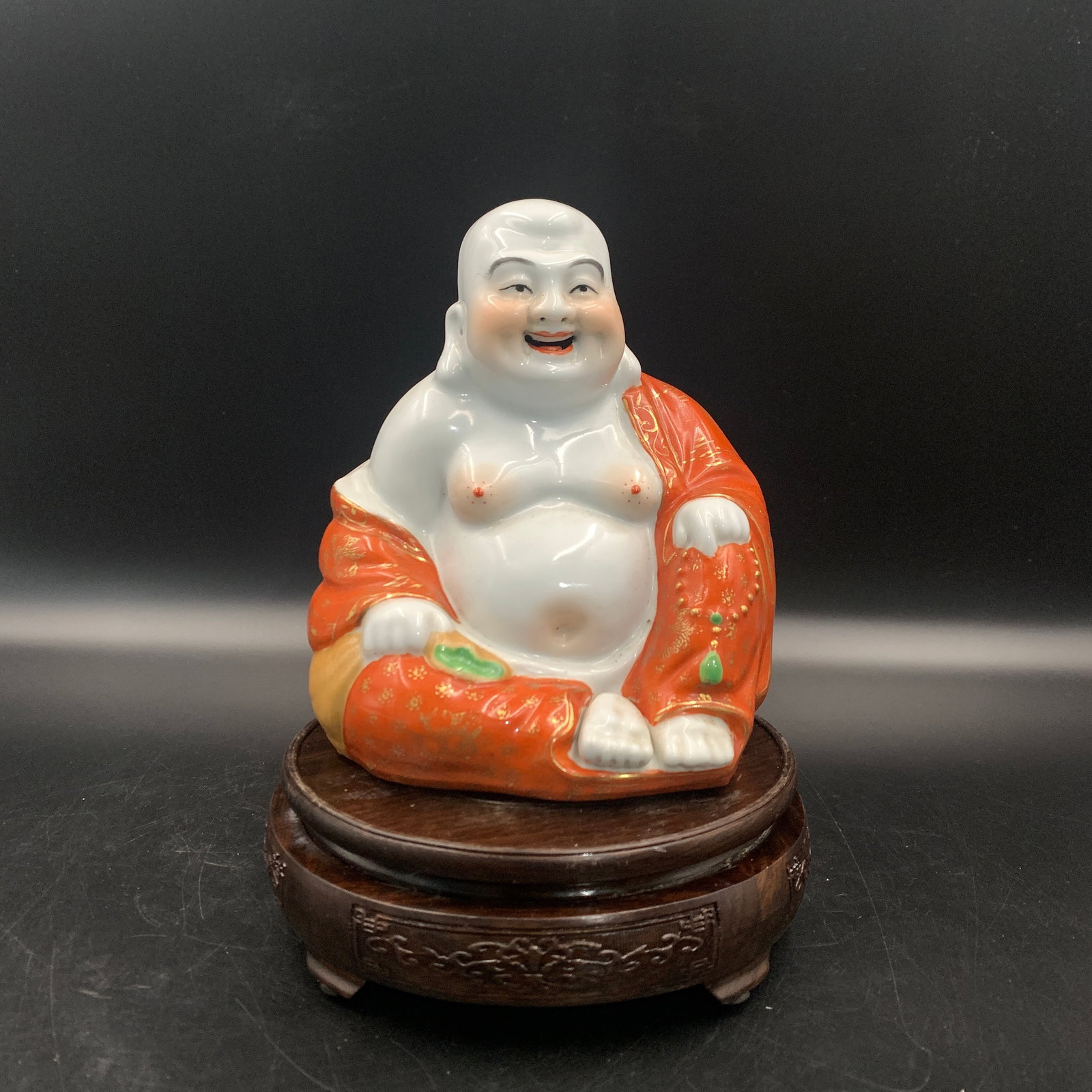ENAMELED PORCELAIN LAUGHING BUDDHA STATUE: Qing Dynasty; Long: 5.6 inch; Width: 4.1 inch; High: 6.5 inch; . Wooden base for display only