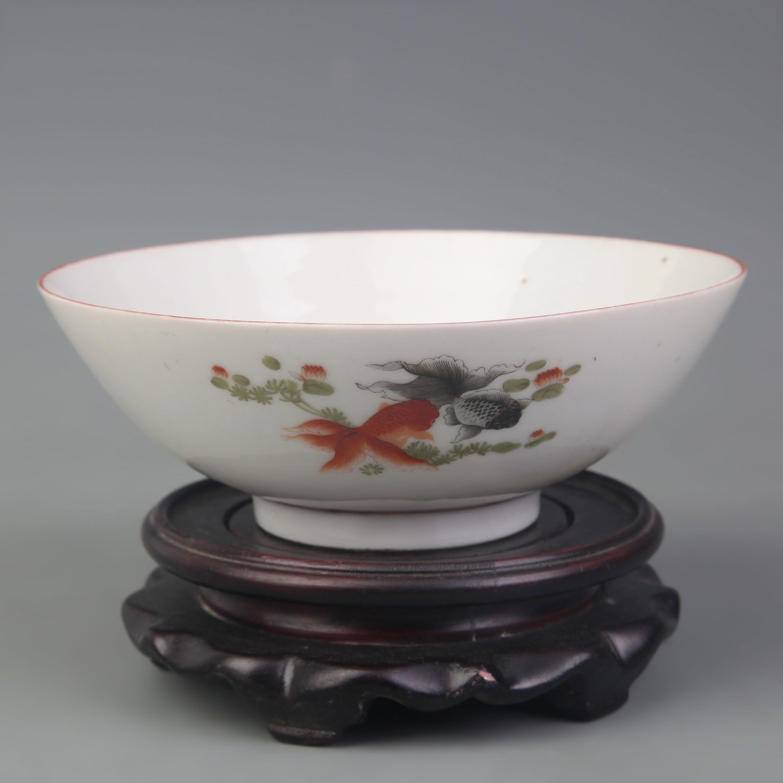 A FAMILLE ROSE FISH MOTIF PORCELAIN BOWL: Qing Dynasty Qian Long Period; Diameter: 6.4 inch; High: 2.3 inch. Wooden base for display only