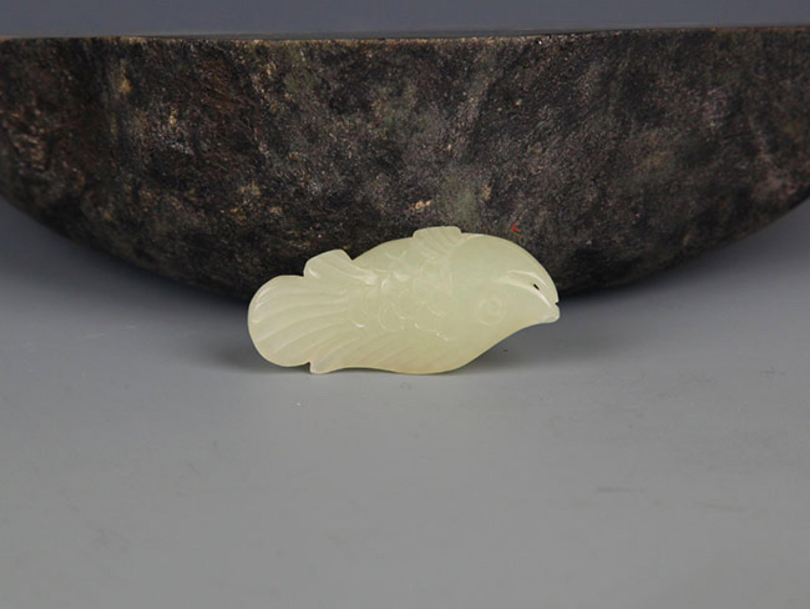 A FINE PALE CELADON JADE IN FIGURE OF FISH: Modern; Long: 1.8 inch; . Wooden base for display only