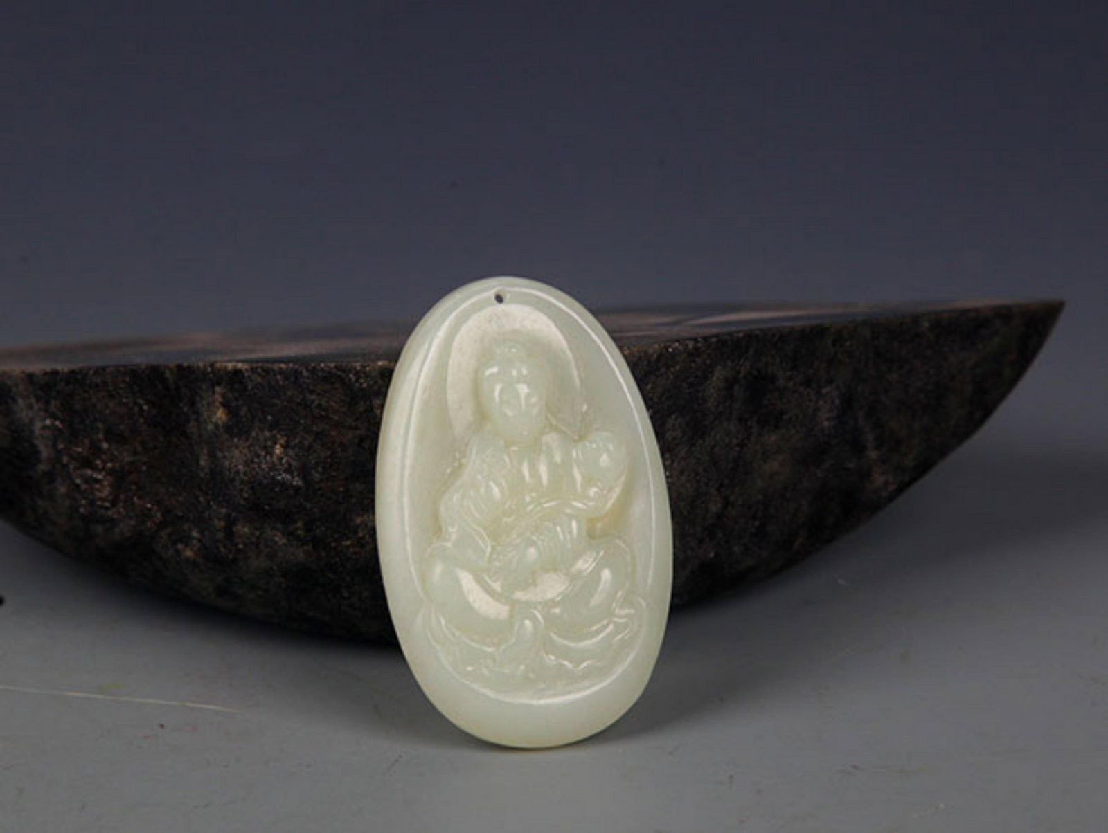 A FINELY CARVED HETIAN PALE CELADON JADE PENDANT