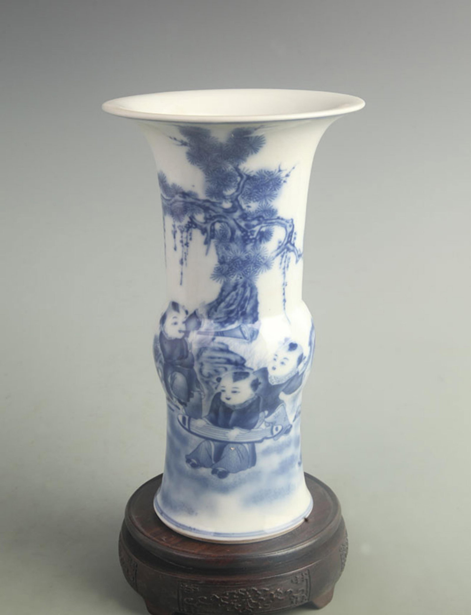 BLUE AND WHITE PORCELAIN VASE WITH BOYS AND FLORAL MOTIFS: Qing Dynasty Kangxi Period; High: 9.80 inch; Diameter: 5.80 inch; . Wooden base for display only