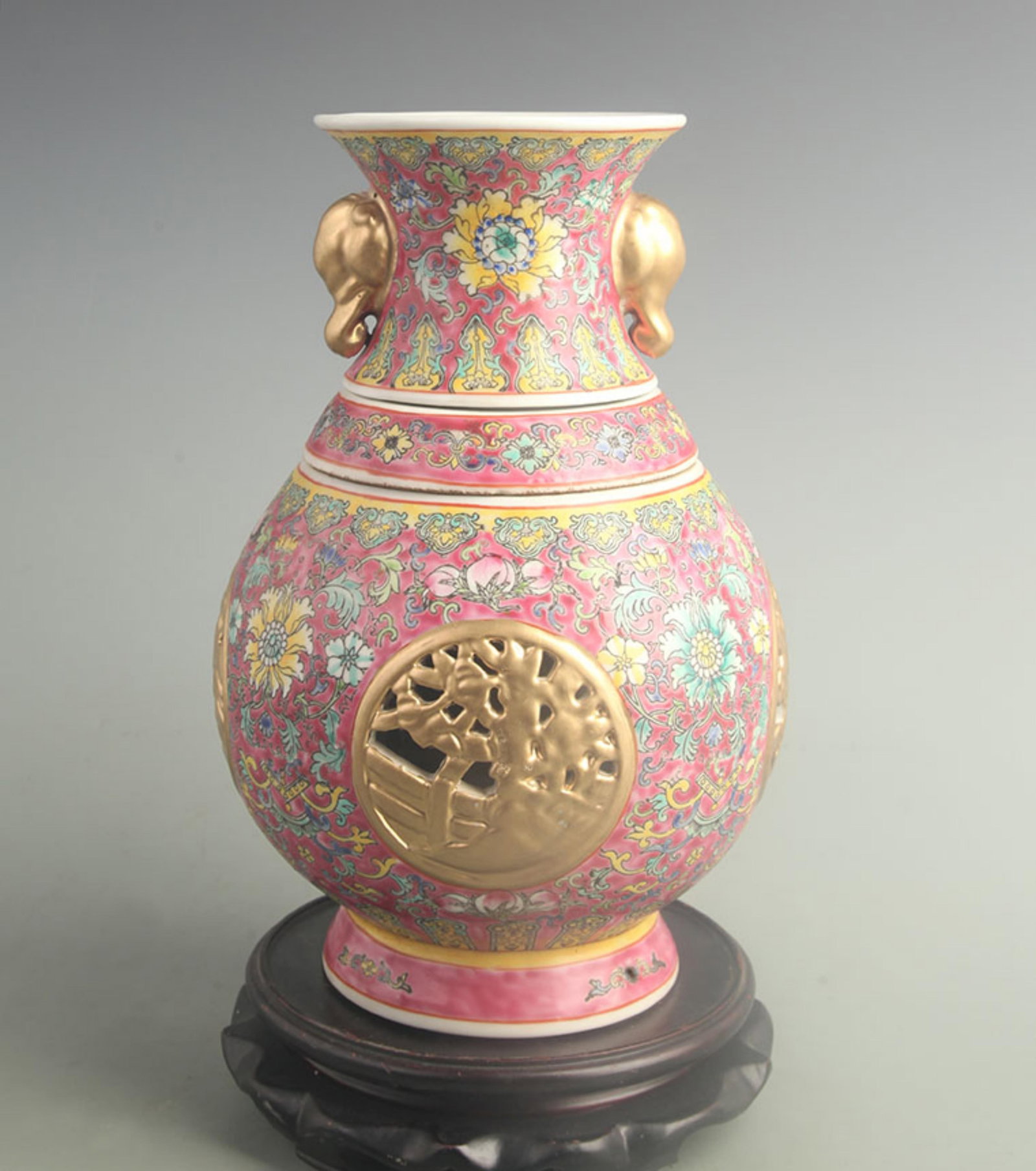 A ROUGE-RED GROUND REVOLVING VASE WITH FLORAL PANELS