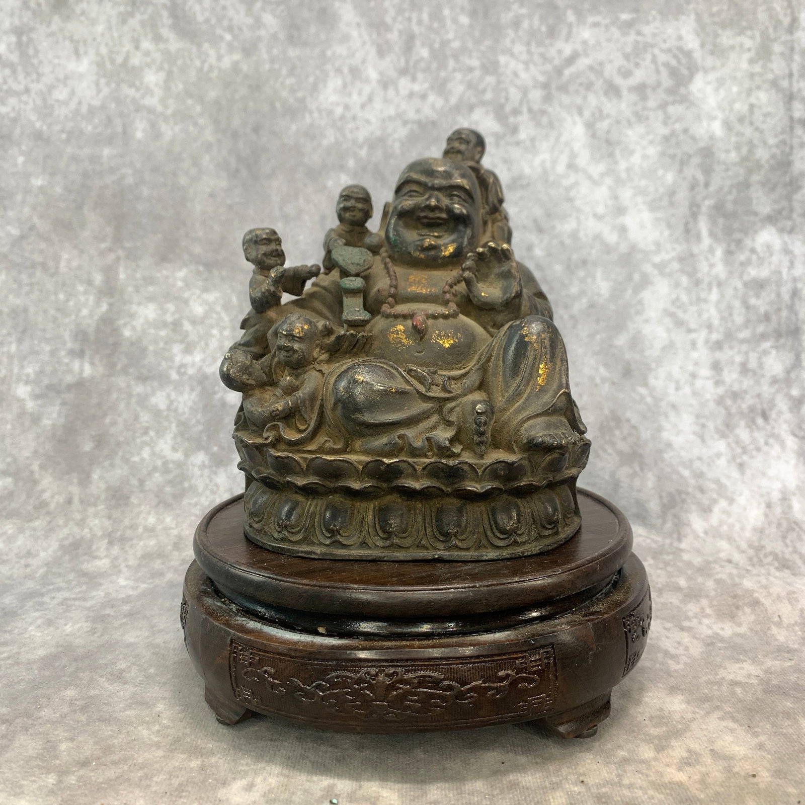 A GILT BRONZE FIGURE OF THE LAUGHING BUDDHA ON A LOTUS THRONE